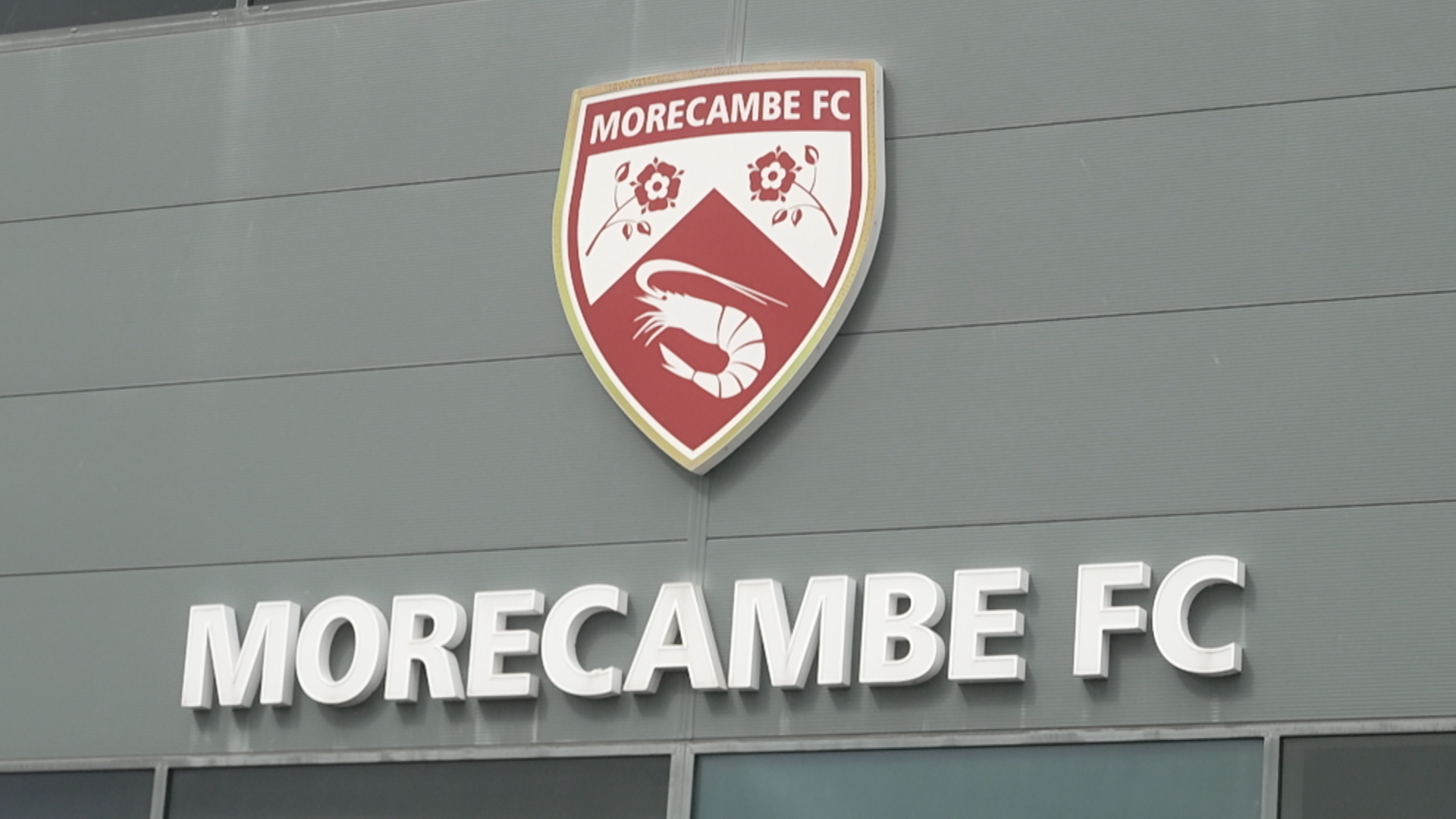 Odznak a meno Morecambe FC Club Sedia na vonkajšej stene mobilného štadióna Mazuma