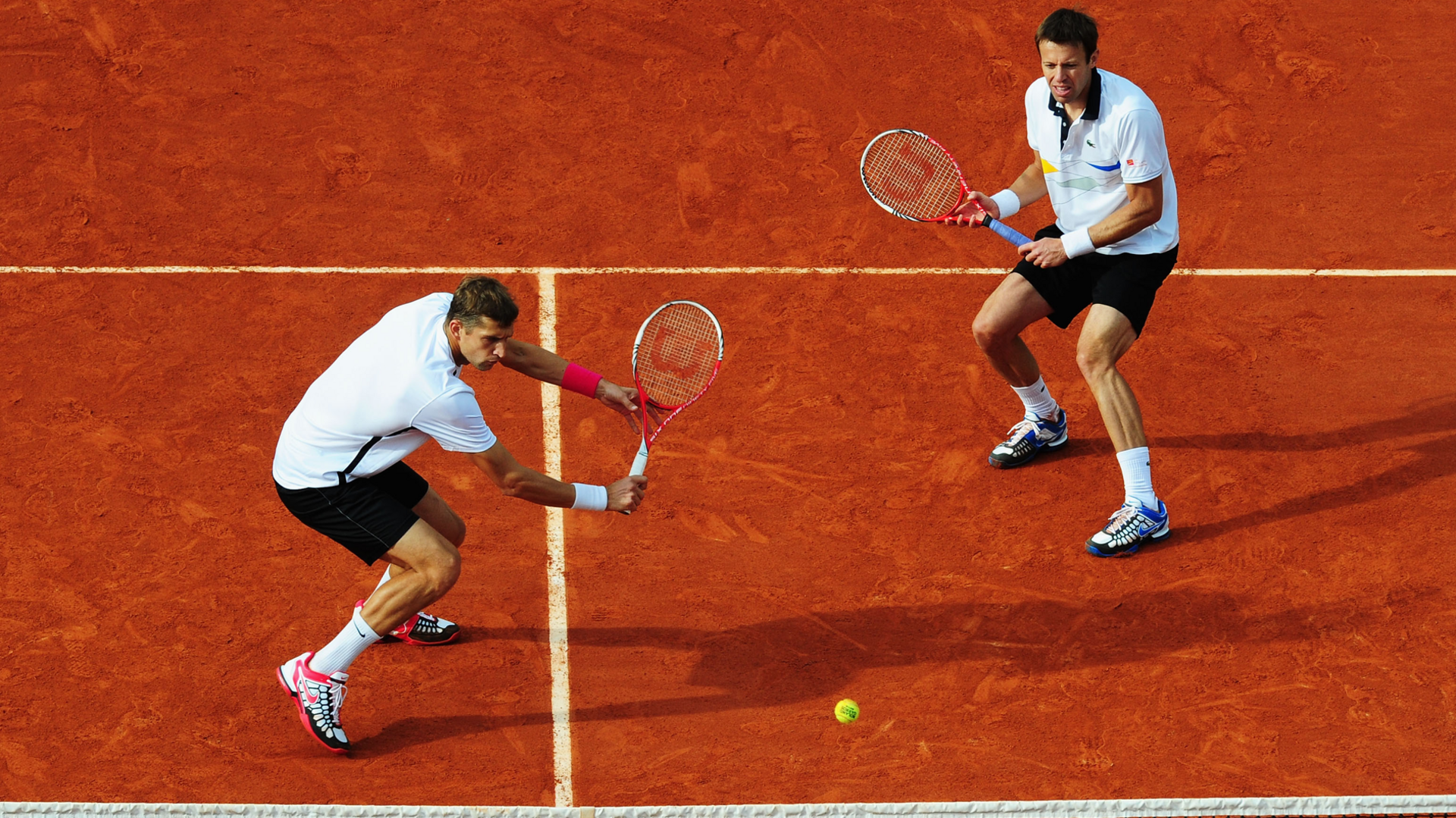 Max Mirnyi of Belarus plays a backhand next to his partner Daniel Nestor of Canada