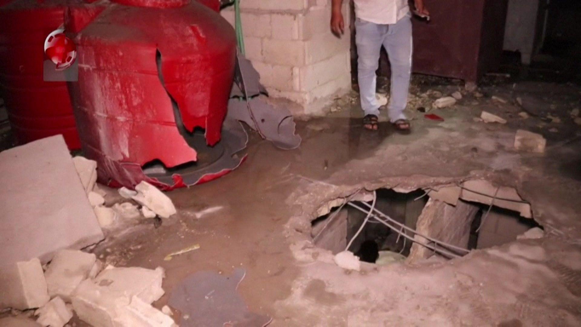 Syrian state-run Al-Ikhbariya al-Suriyah TV footage shows a Syrian man standing next to a hole in the roof of a building reportedly hit in an Israeli strike in the Syrian port city of Tartous (9 September 2024)