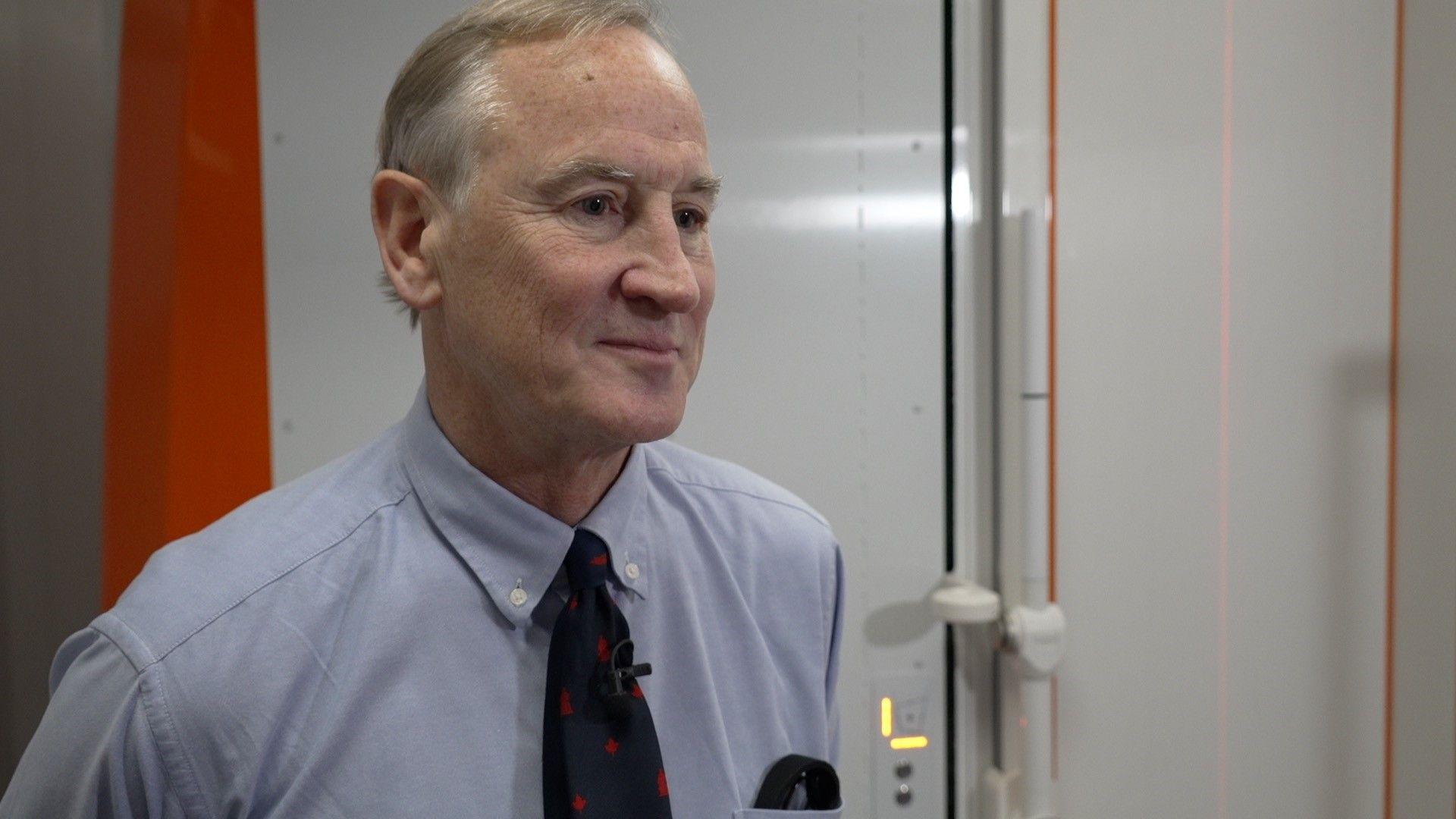 Jonathan Lucas in a blue shirt and blue and red tie. 