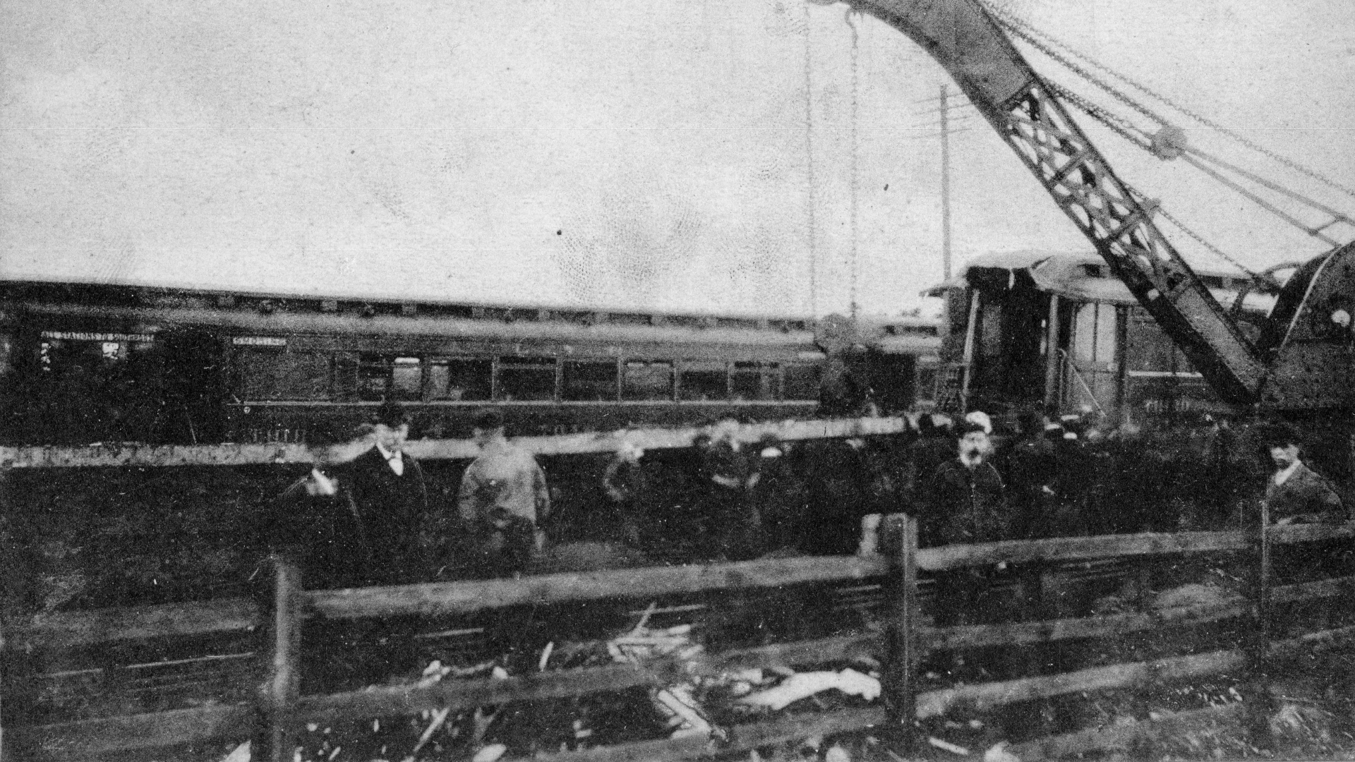 A black and white photo of work to remove the crashed locomotive.