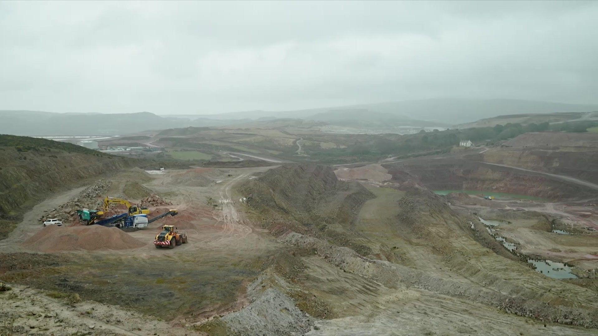 A general view of a mine showing machinery and dirt roads on a cloudy day.
