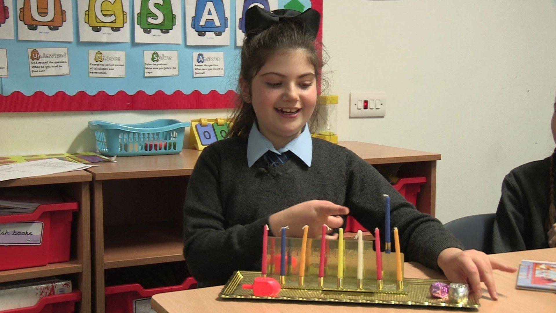 This girl shows us her Hanukiah, with nine candles.