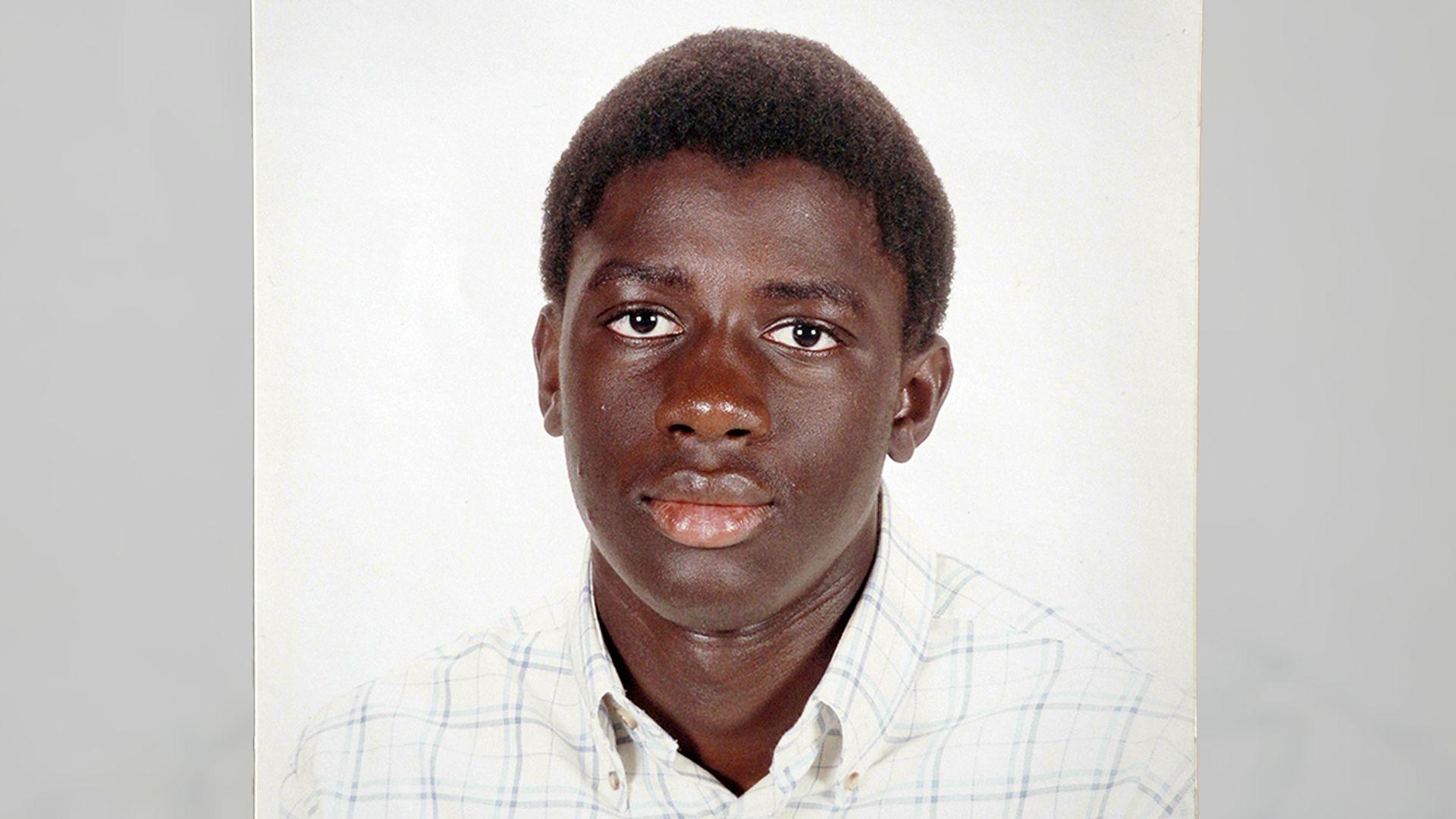 A family photo of Valdo Calocane as a teenager, wearing a white checked shirt with a button-down collar and looking directly at the camera