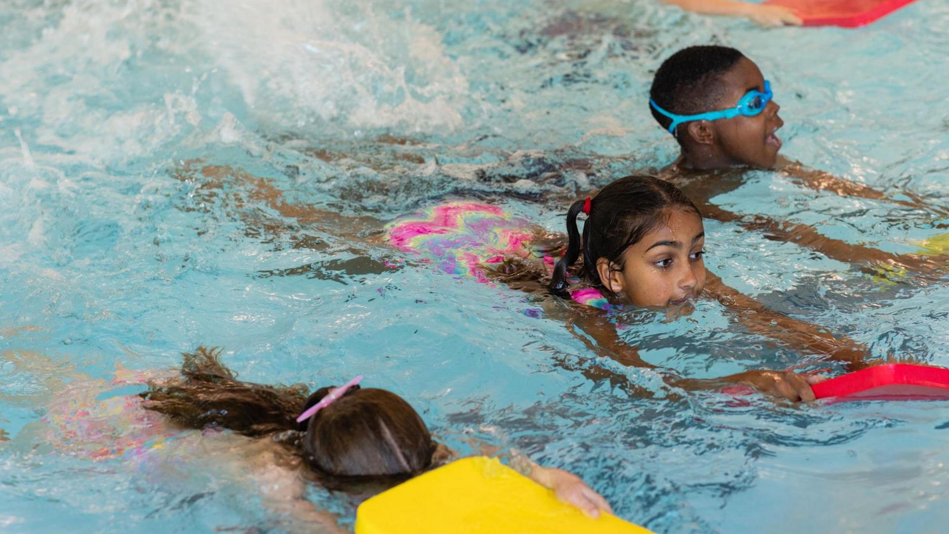 A radical  of children swimming utilizing swimming floats successful  a swimming excavation  