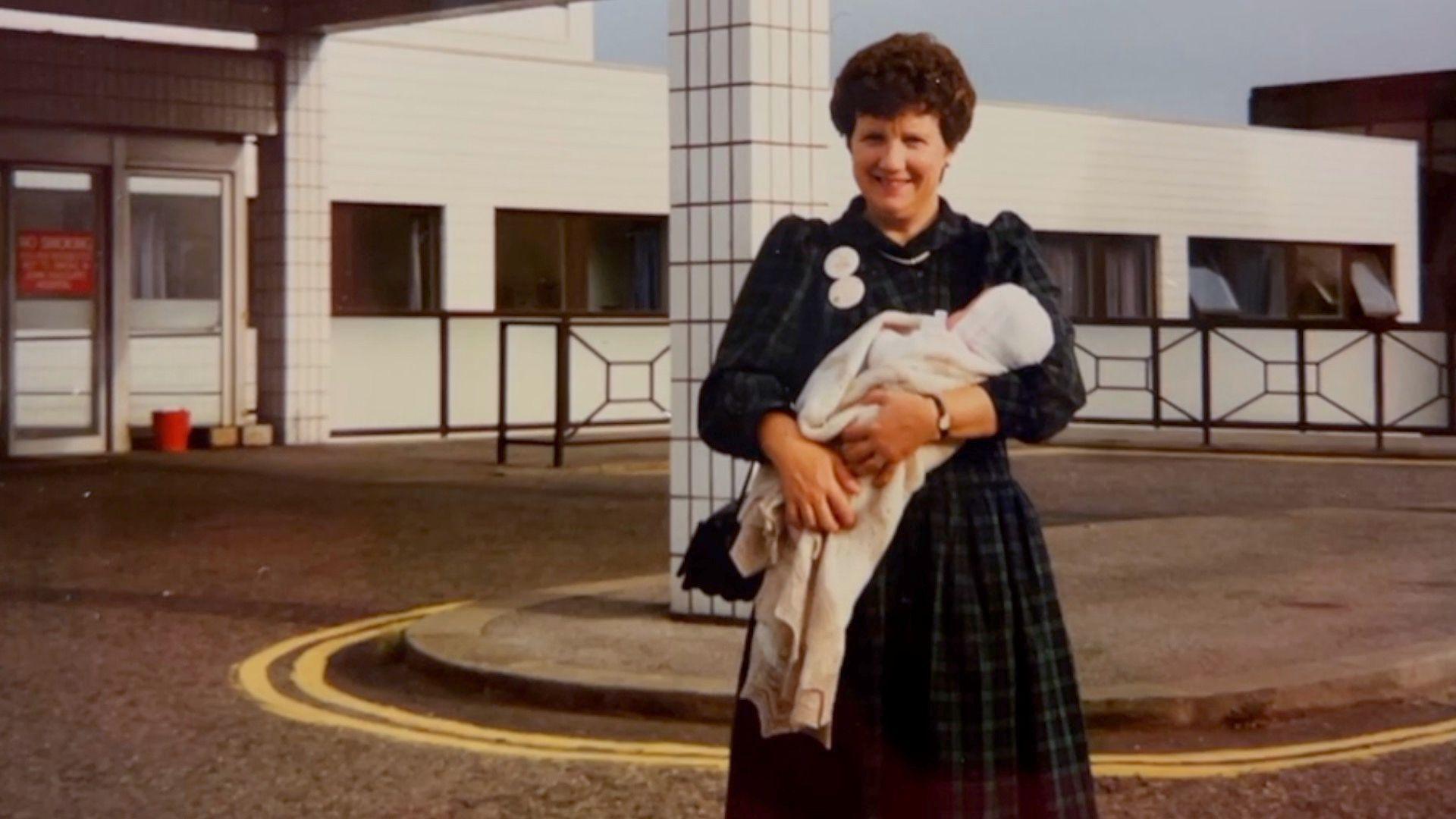 Ms Harris's mother holding her as a baby outside the hospital. Photo taken in 1989.