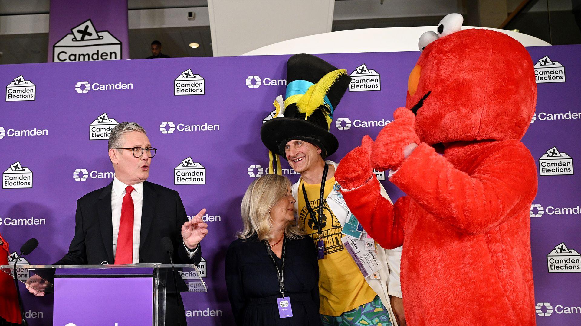 Leader of Labour Sir Kier Starmer addresses a candidate dressed as Elmo, after winning his constituency seat