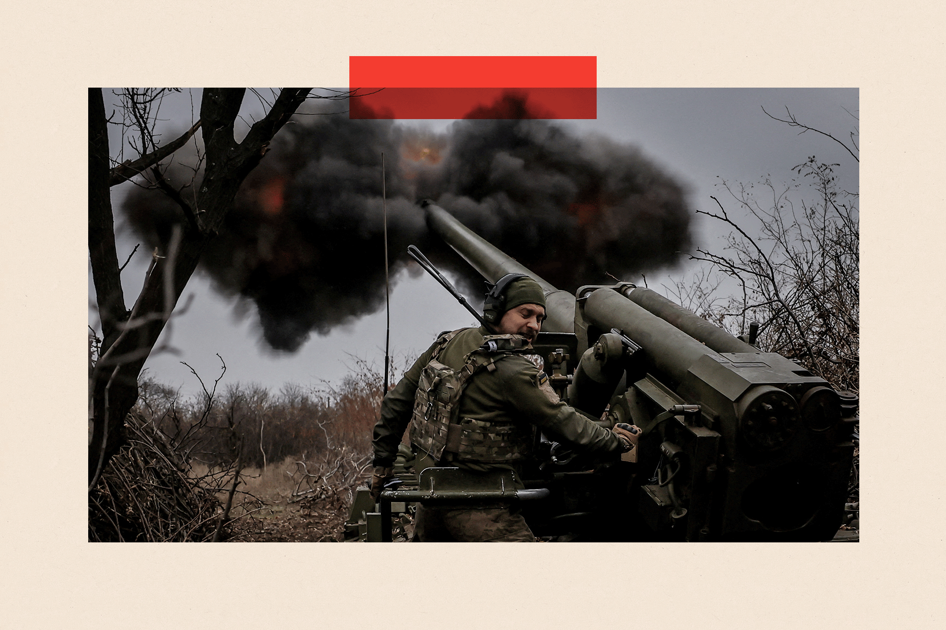 A Ukrainian soldier fires a self-propelled howitzer at Russian troops. He looks away as it fires black smoke into the sky