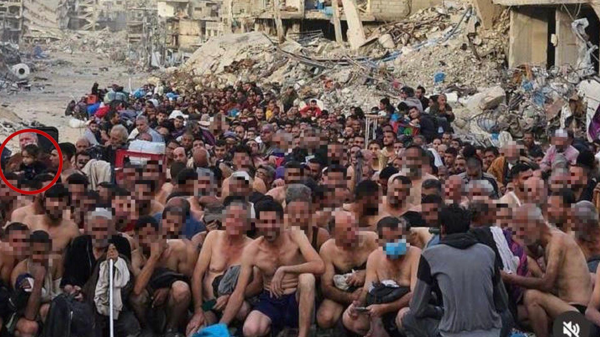 A group of dozens of detained Gazan men pictured in their underwear, during what appears to be an Israeli check for weapons and signs of any links to Hamas. They are sitting or squatting, some young and some older. At the far left of the picture, in the middle of the group, a little girl with dark hair can be seen. The BBC has chosen to blur the faces of the men nearer the front of the picture. In the background is a destroyed building, collapsed into rubble.   