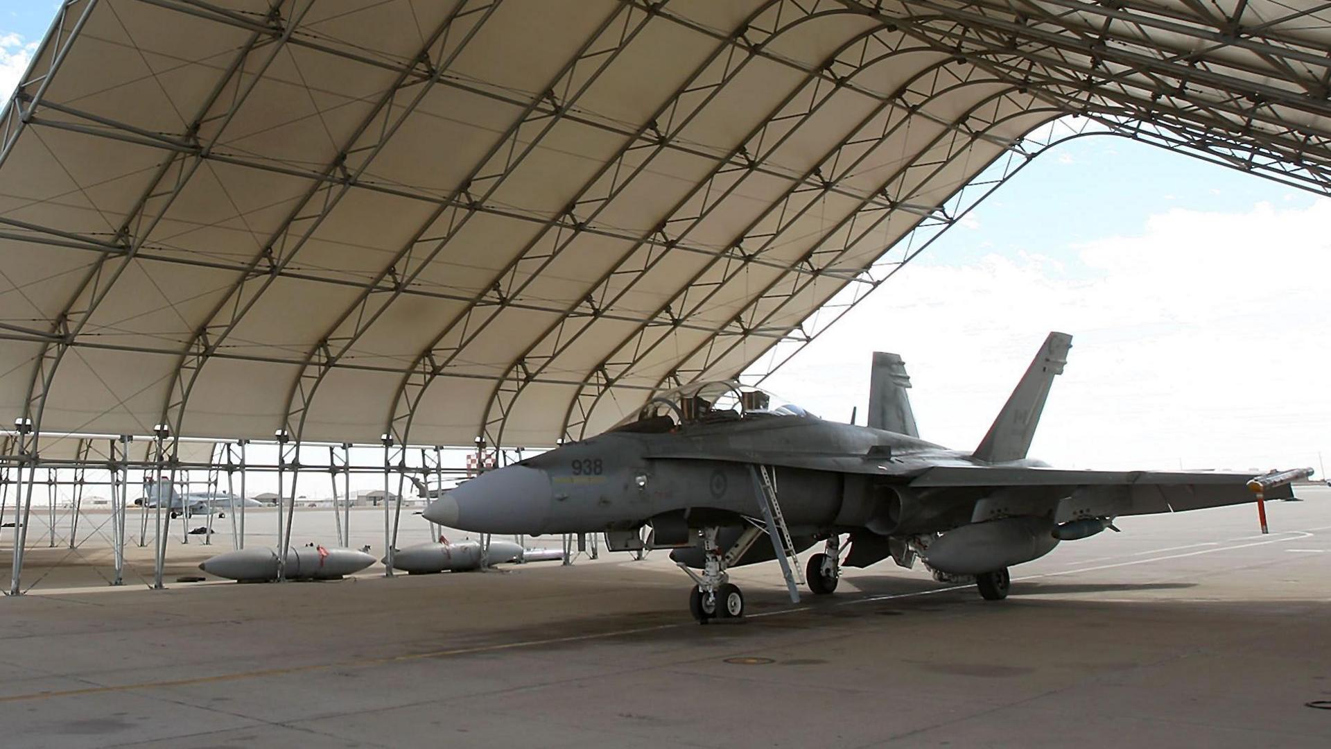 A Canadian hornet under shelters on the tarmac at Naval Air Facility (NAF) El Centro near El Centro, California