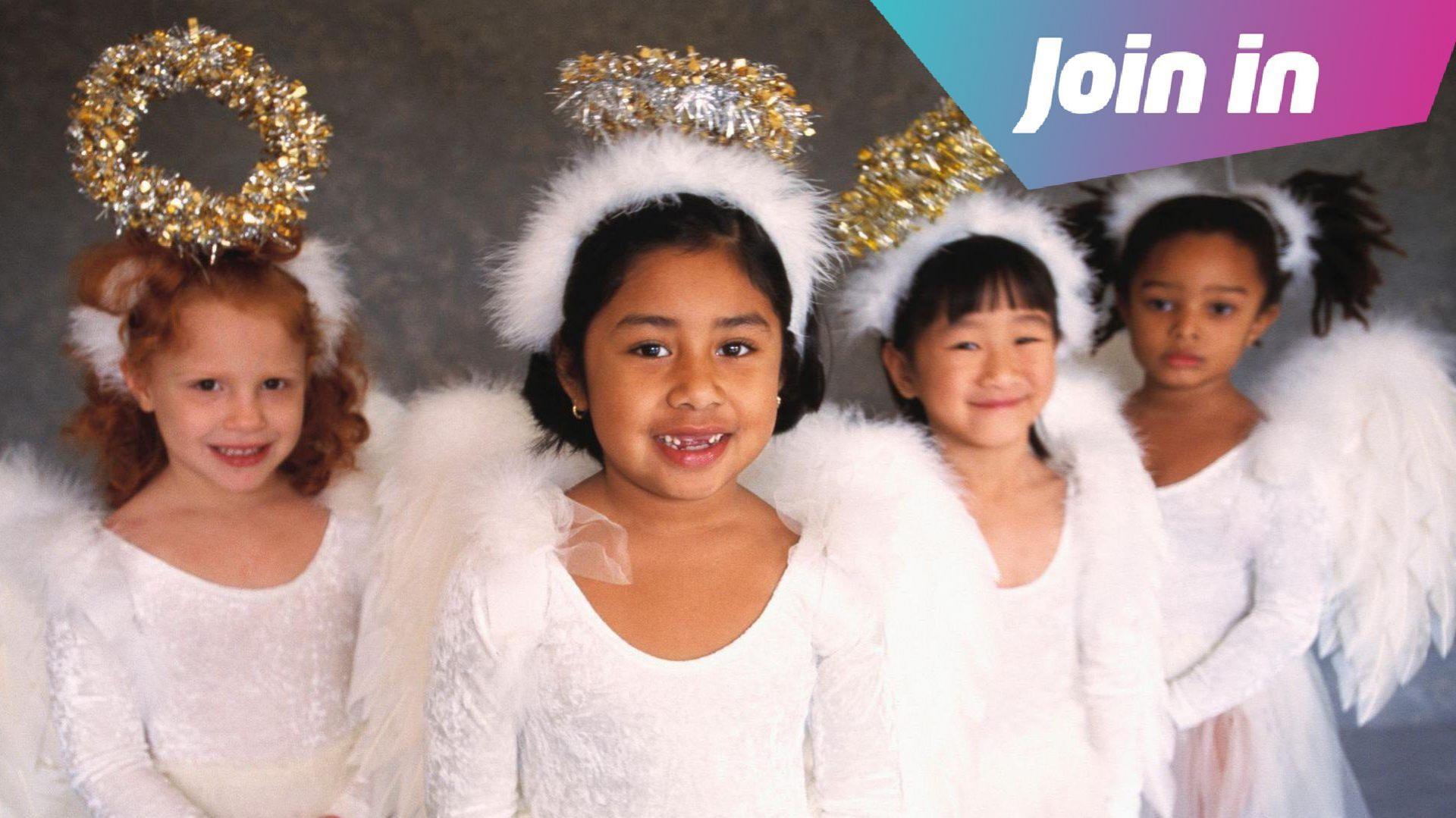 Four girls dressed up as Christmas angels wearing halos and wings.