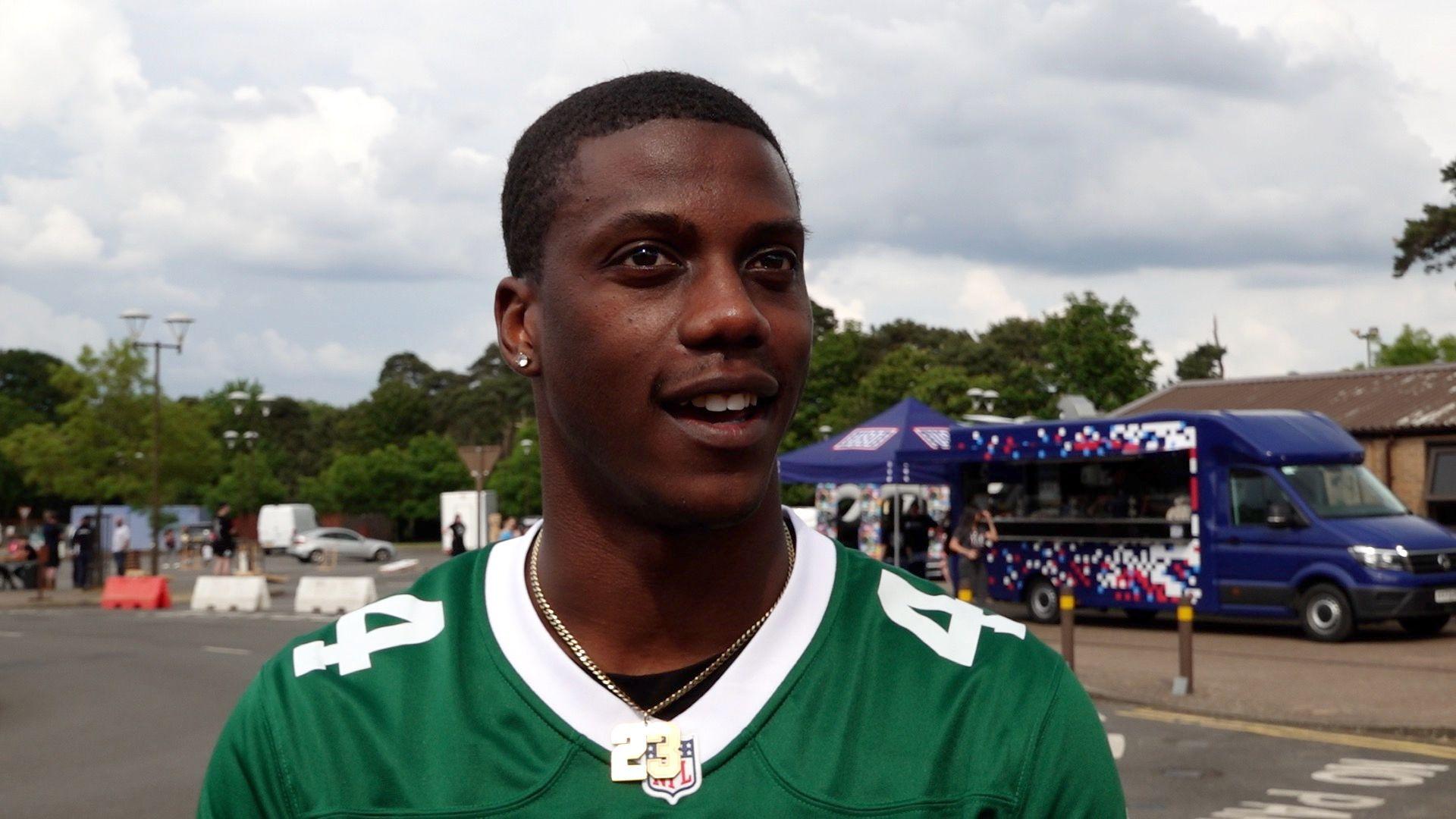 London Murrell with short black hair wearing a green football shirt