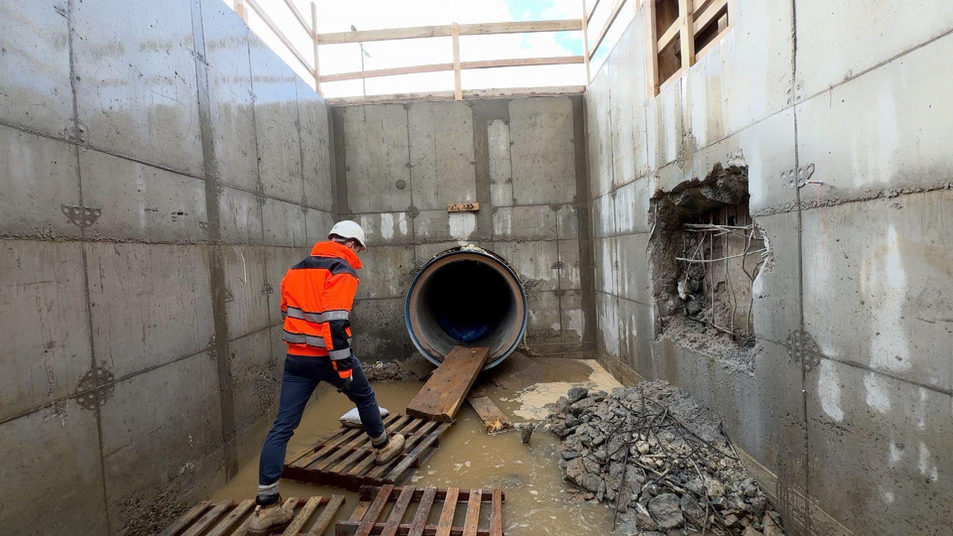 Tom Le Gallais at the upgrade site. He is walking at the entrance to the reinforced concrete pipe. 