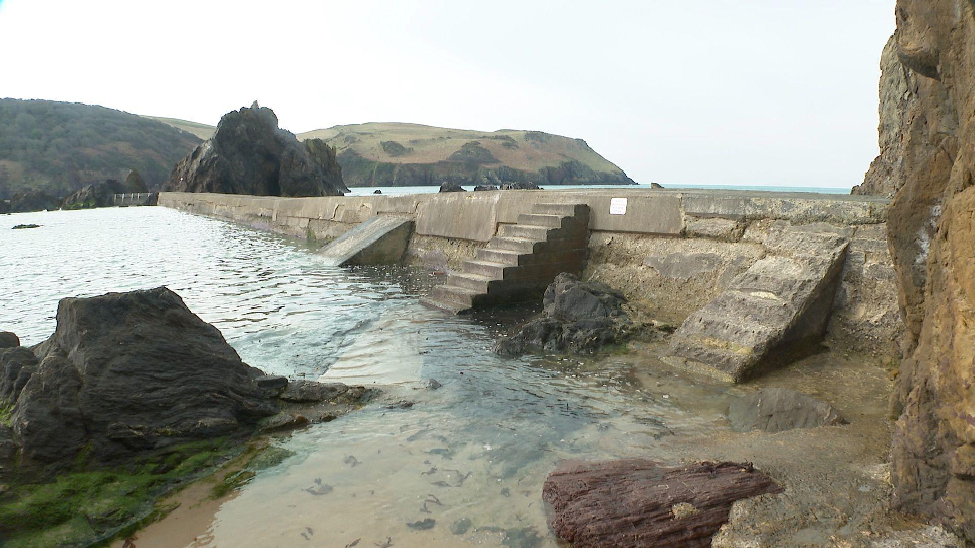 The Hope Cove Breakwater on a calm overcast day with flat seas.