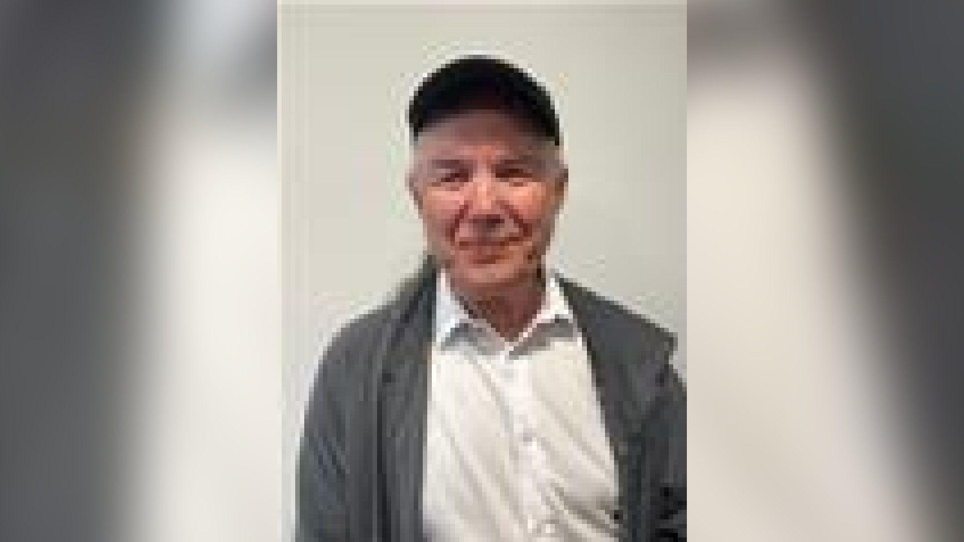 Image of Mark Broadhurst from the waist up. He is wearing a white shirt and a grey jacket as well as a black cap. He is smiling at the camera.