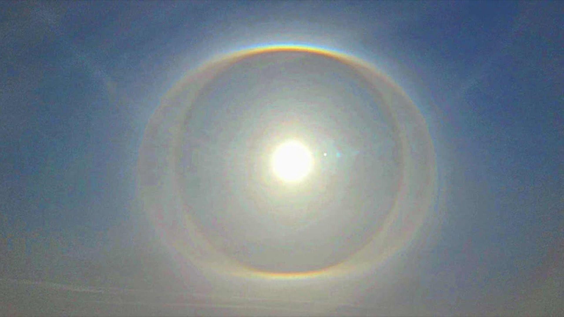 Sun with a halo around it and blue sky.