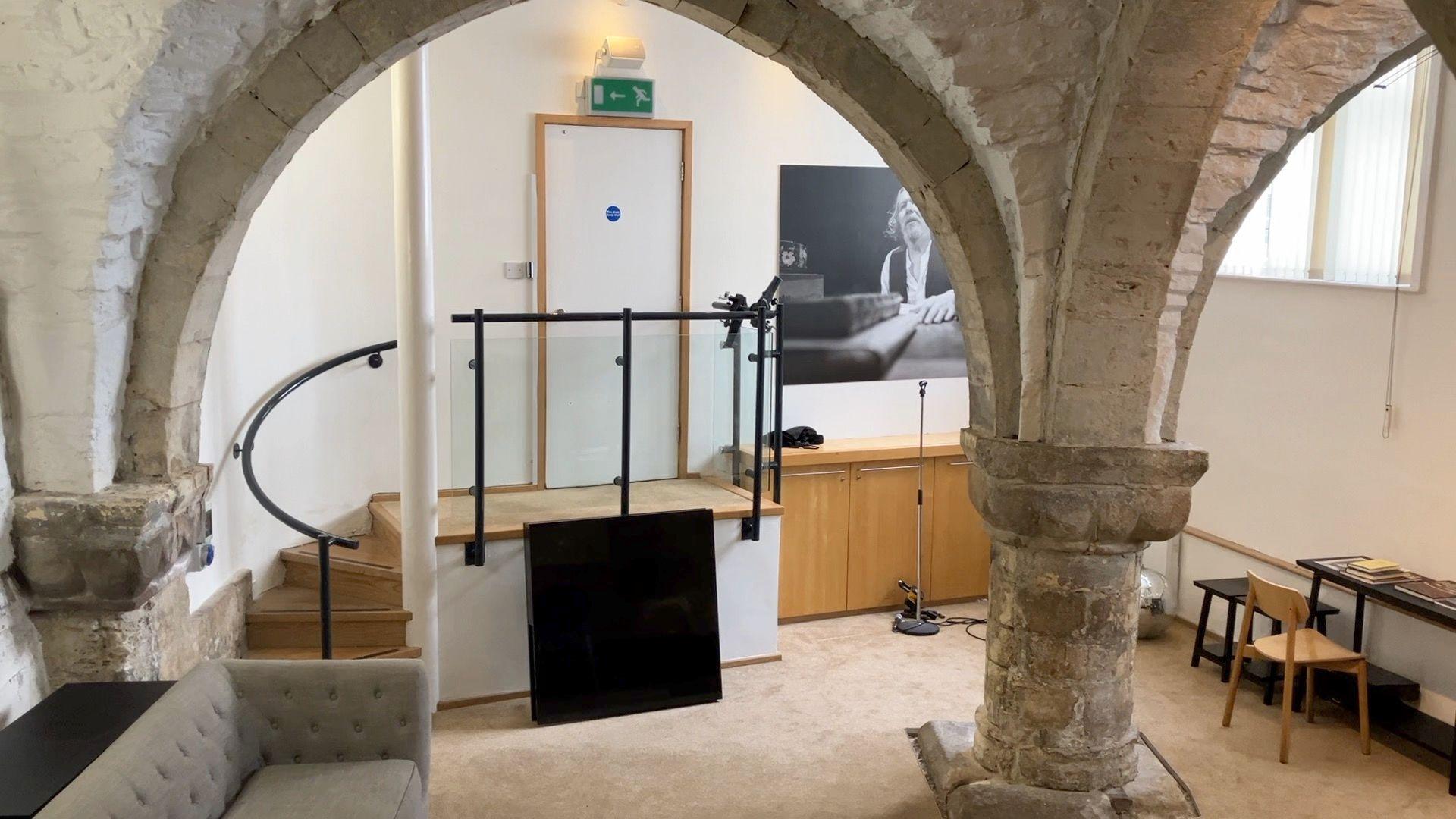Large medieval stone pillars in a soft furnished room.