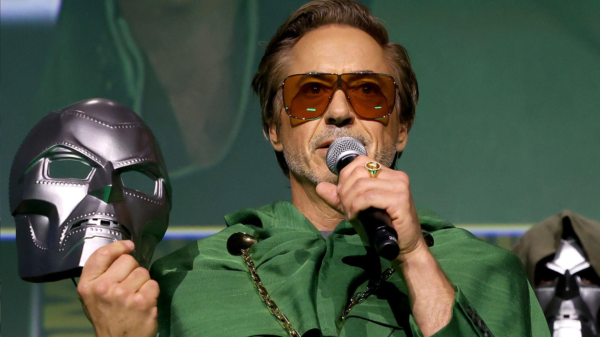 Actor Robert Downey Jr holding the mask of Doctor Doom and speaking to Comic-Con