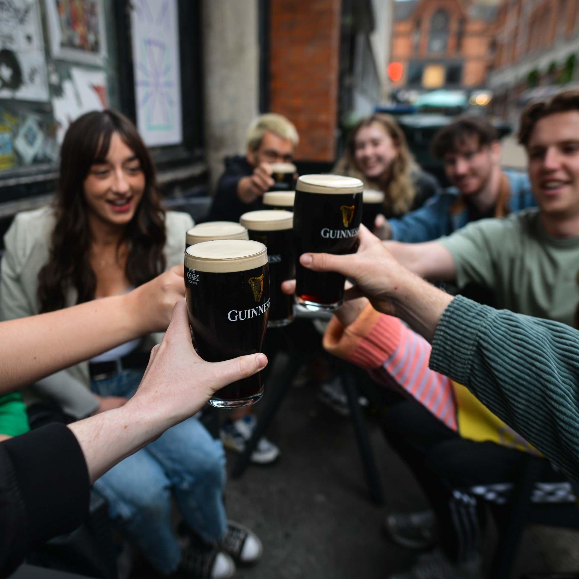 People enjoy drinking Guinness outside a pub in Dublin, Ireland