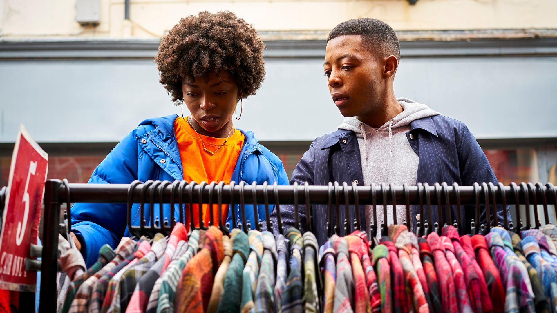 Stock photo shows two people looking down at a rail of clothes at an outdoor market at an unidentified location in the UK.