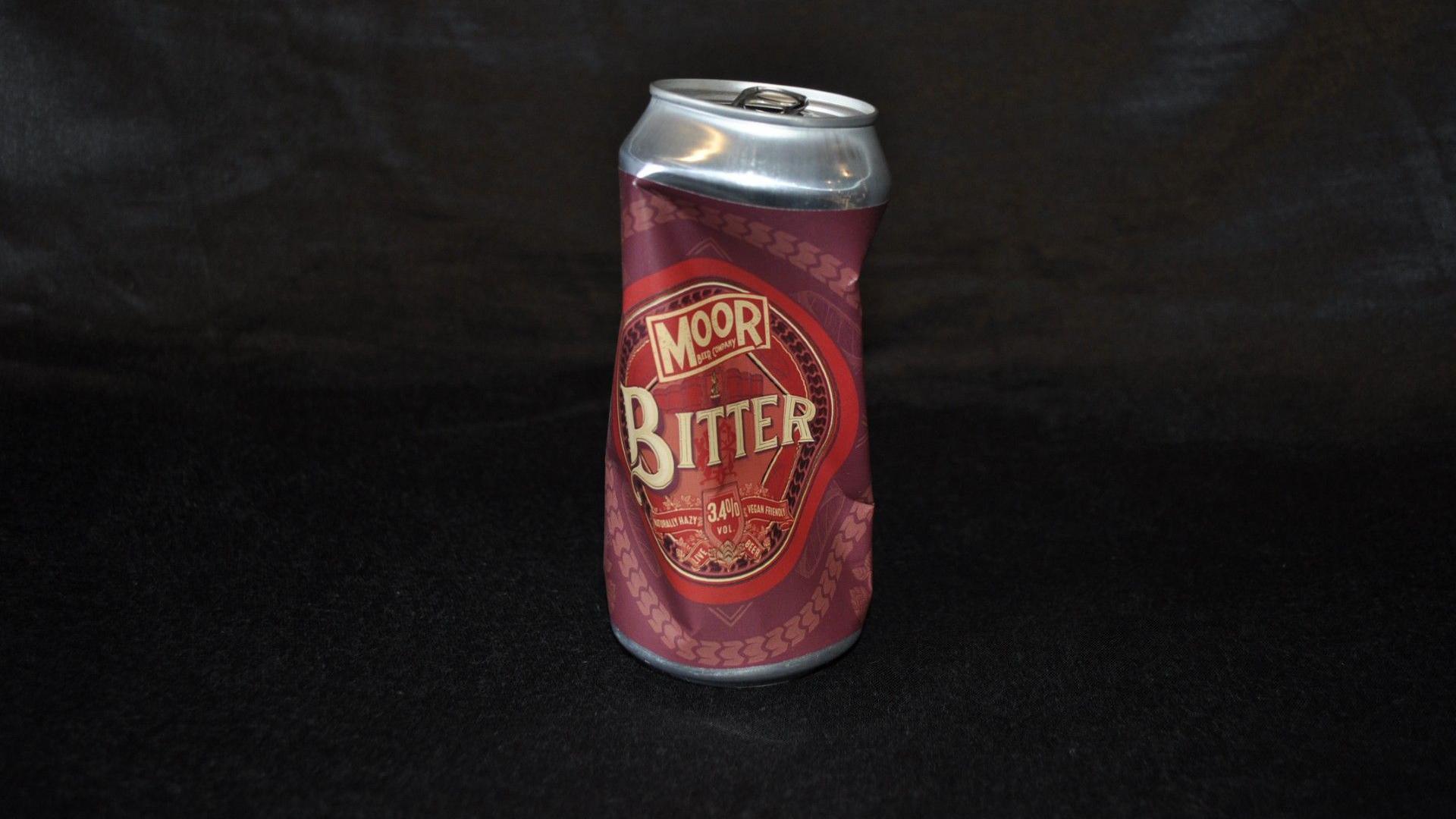 A crushed can of bitter beer made by Moor brewery. The label is a mix of red and maroon.