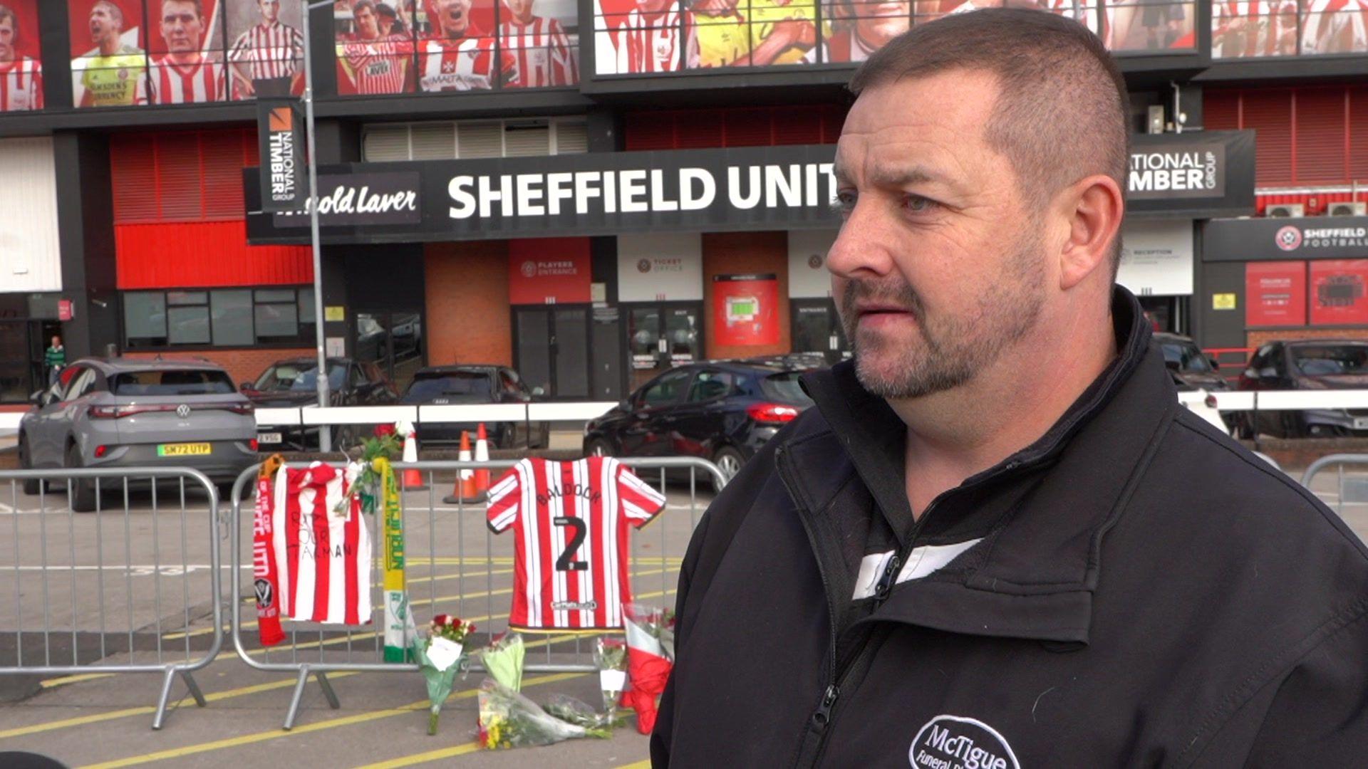 A man wearing a black top outside Bramall Lane