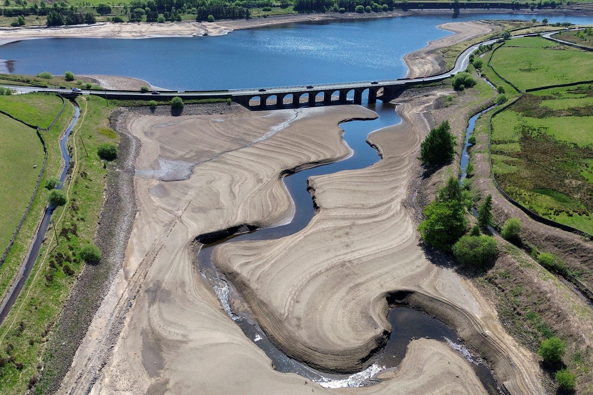 An aerial view shows a meandering river with low water levels next to a bridge over the resevoir at Woodhead Resevoir on 11 May.