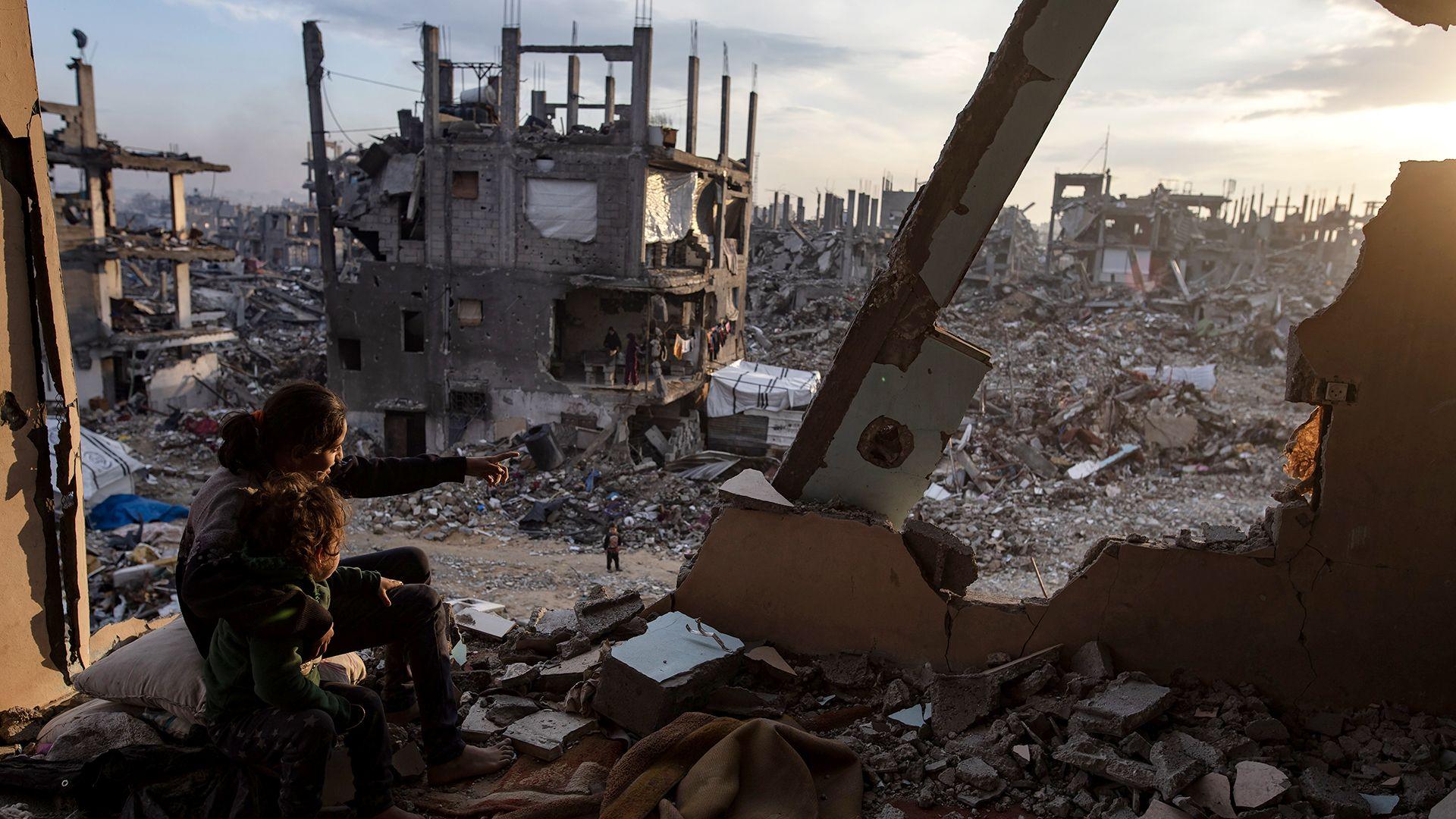 Palestinian children watch the sunset from the destroyed house in Jabalia refugee camp, north of Gaza City (11 February 2025)