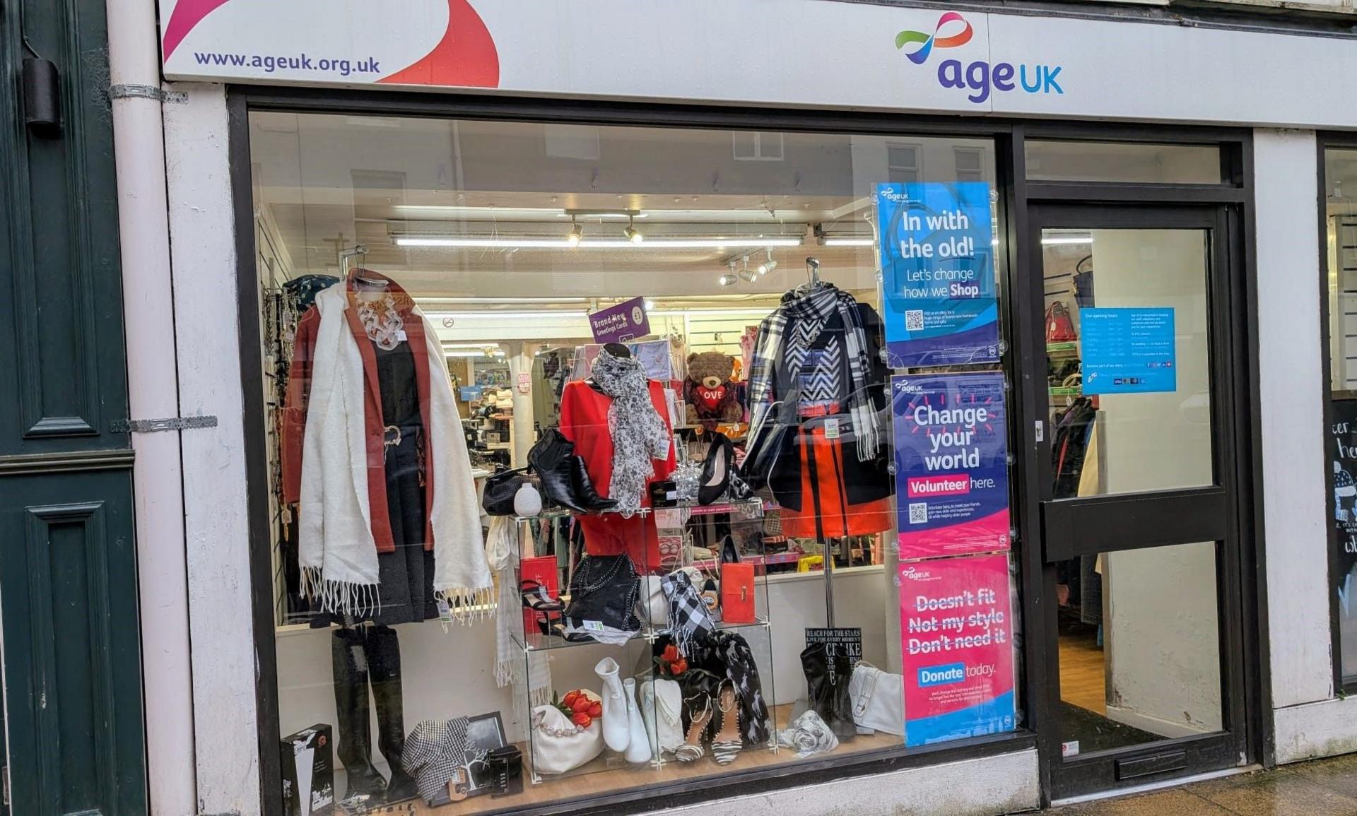 A front window of a shop with lots of black-and-white merchandise on sale.