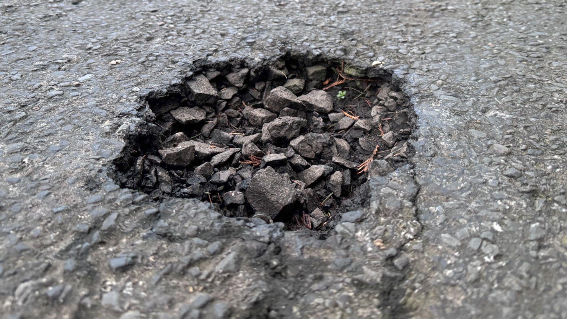 A close-up picture of a filled-in pothole