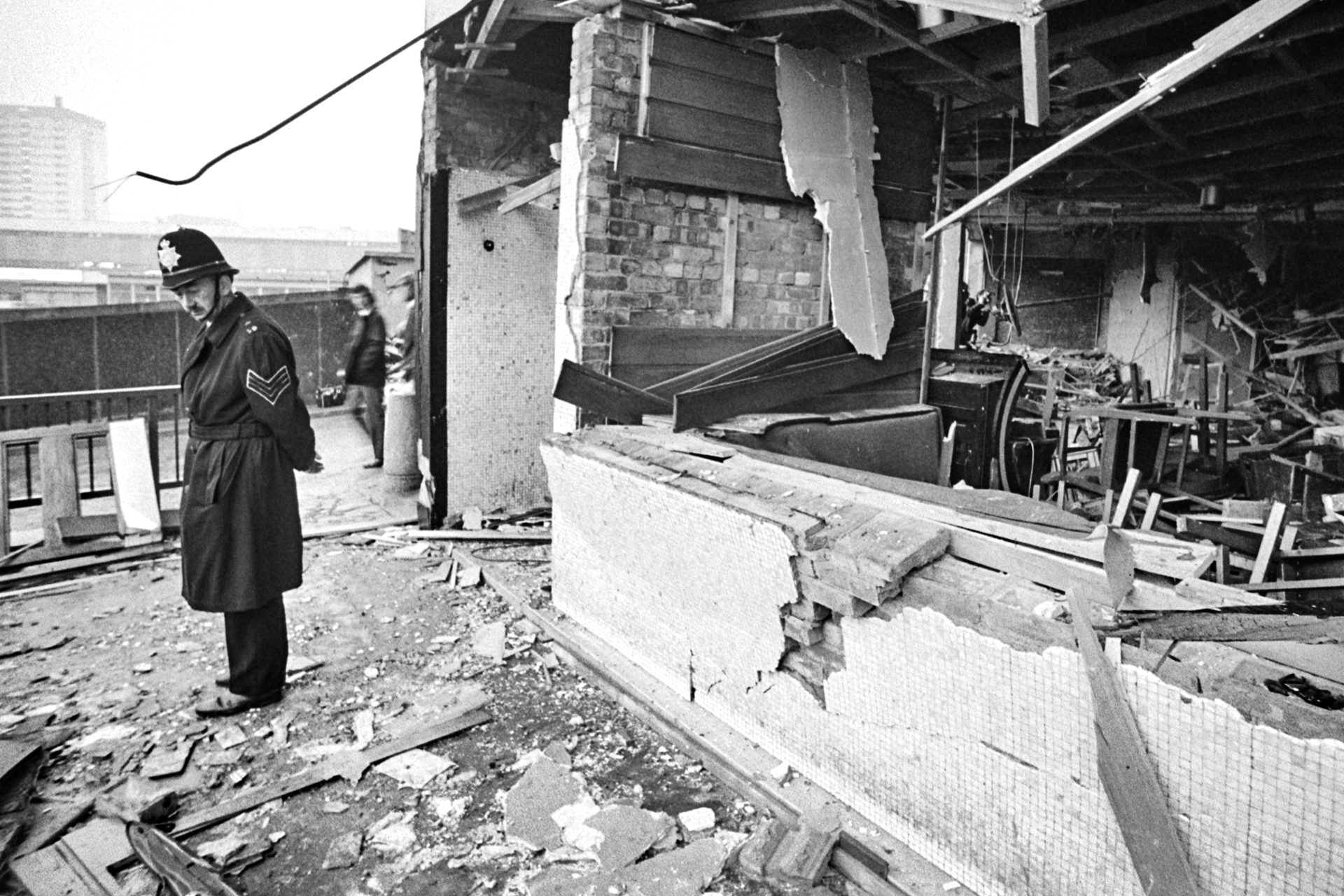 A police officer stands outside the remains of the Mulberry Bush pub on New Street, Birmingham, surveying the aftermath of the bombing.