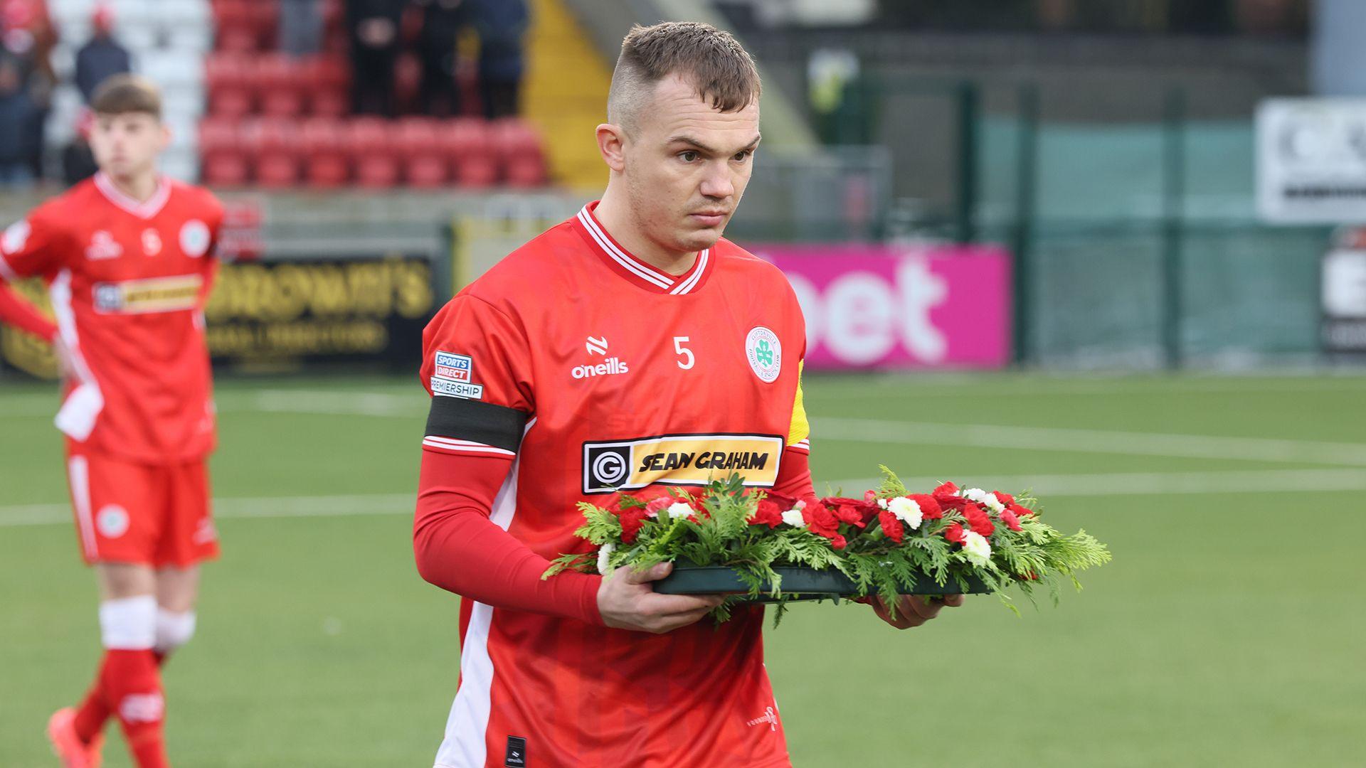 Rory Hale lays a wreath ahead of the match