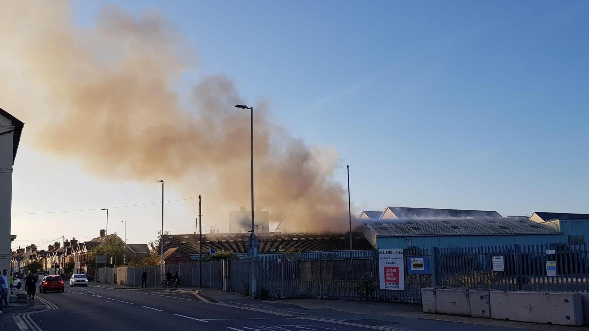 A large smoke plume comes from an industrial building.