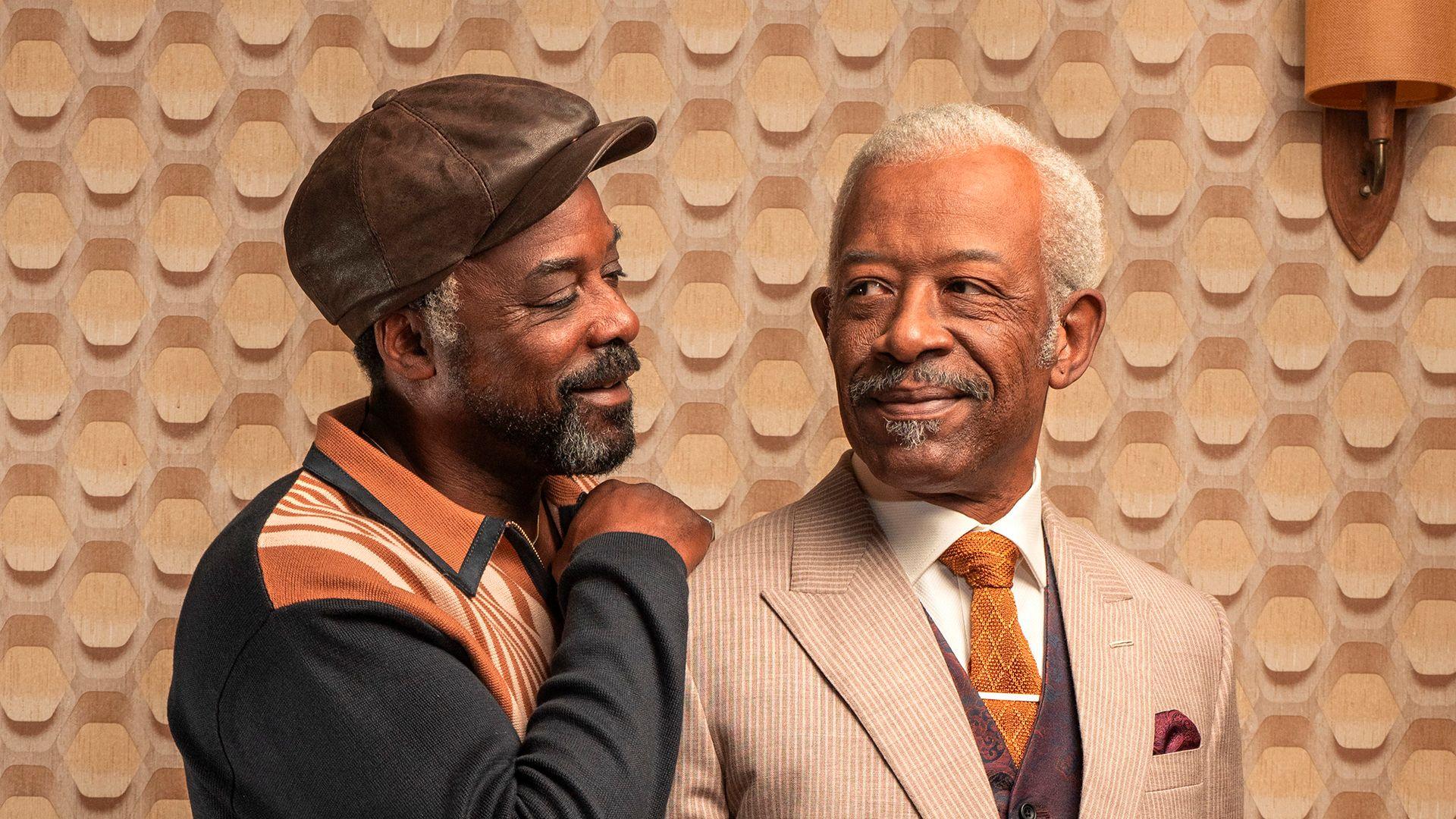 Lennie James and Ariyon Bakare in character, looking lovingly at each other in a 1970s living room