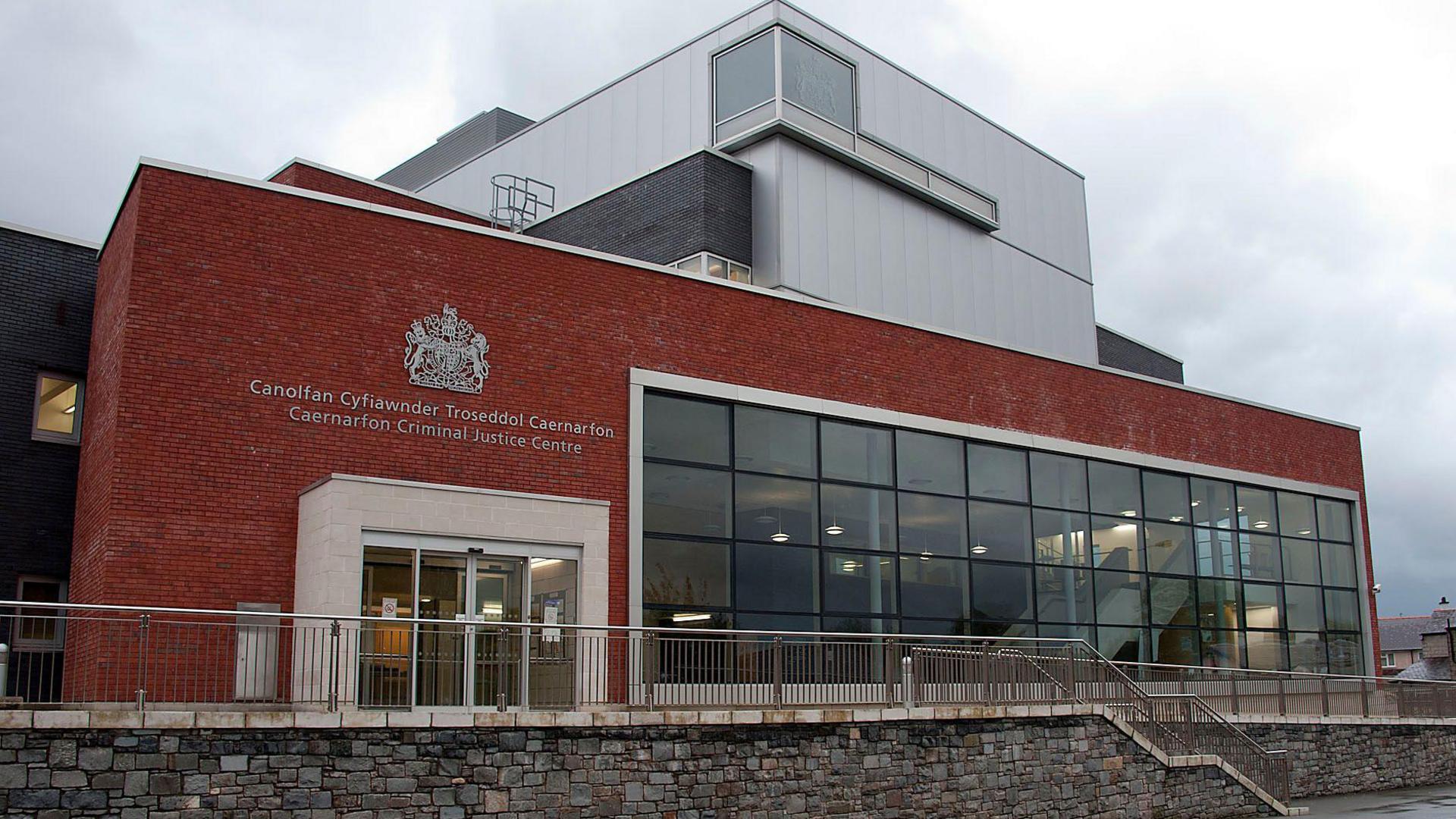 Caernarfon Justice Centre a red brick building with a two storey bay window across half the front of and a third story with silver metal cladding