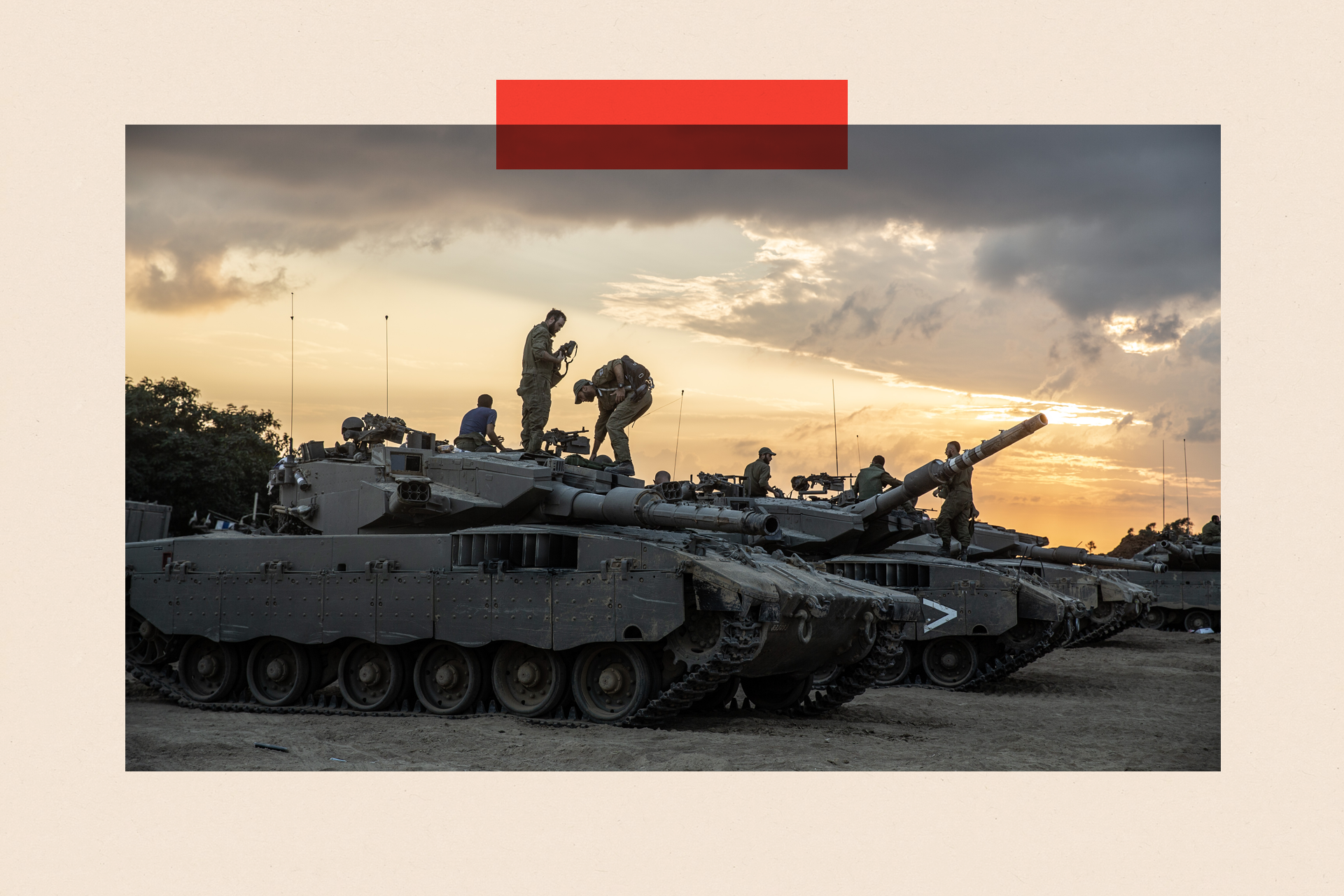 Soldiers stand on top of military tanks and armoured vehicles, as the sun begins to set in the background.