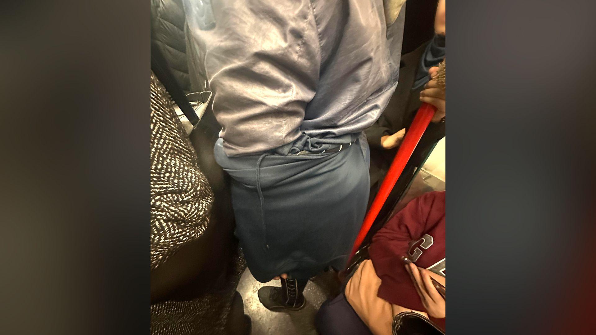 A photo taken on a busy tube, which captures Levy using his clothing to conceal his hand