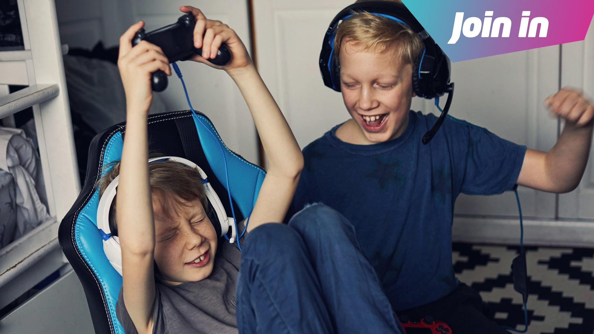 Two boys play on a gaming device 