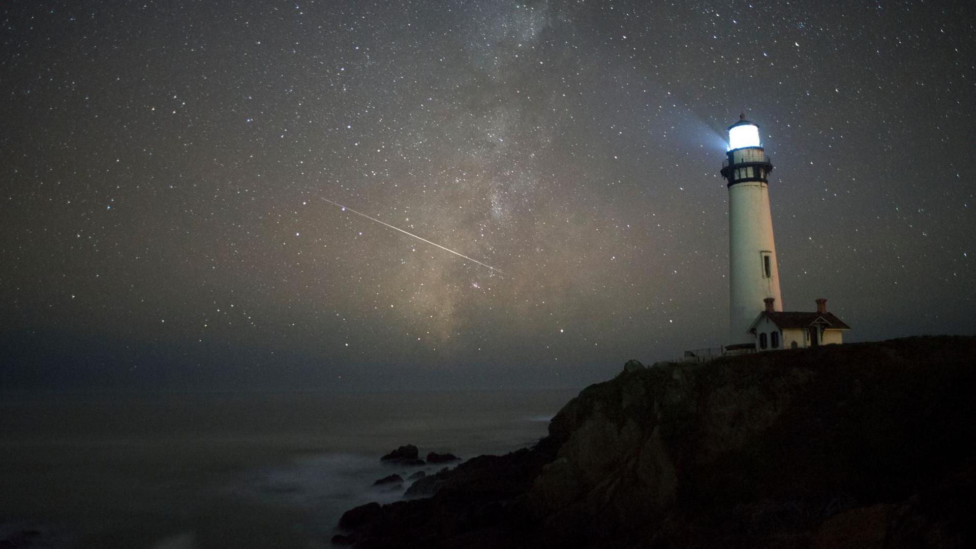 Shooting stars near a lighthouse