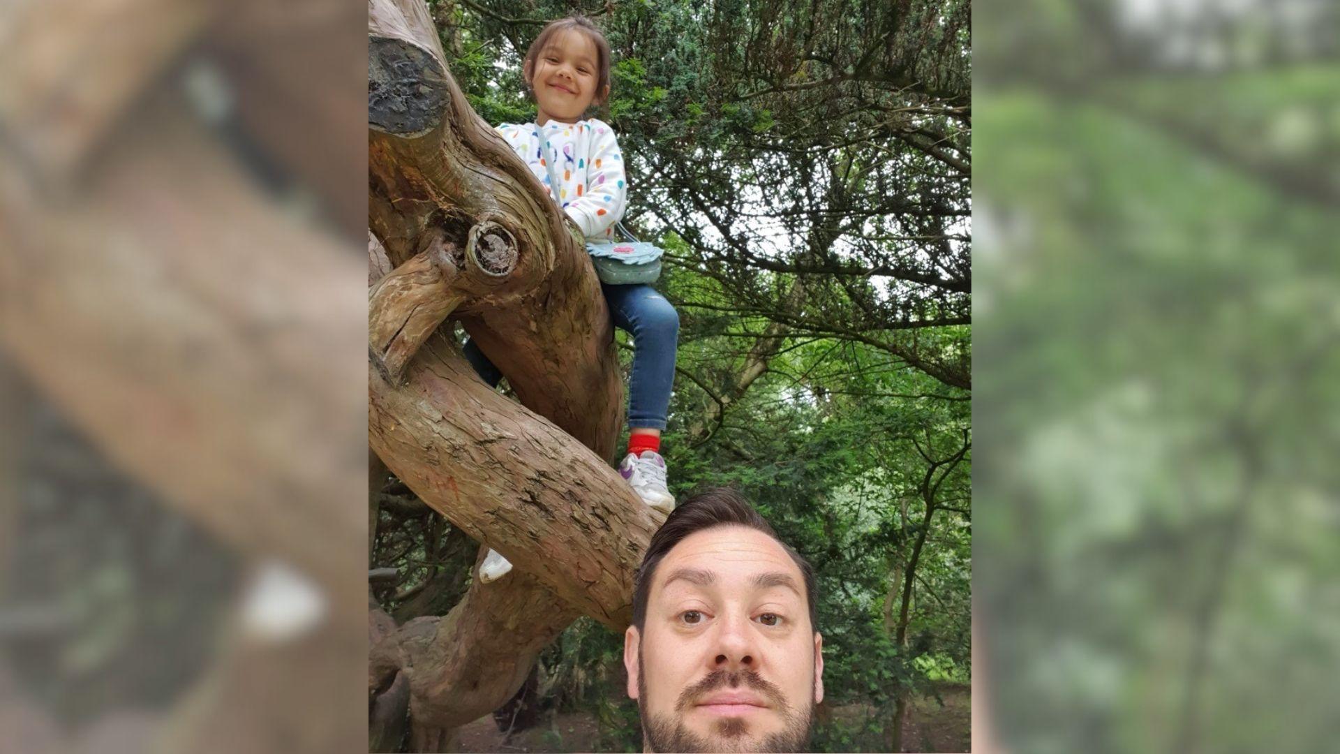 Jamie taking a selfie with Vesper whilst she is sat on a tree.