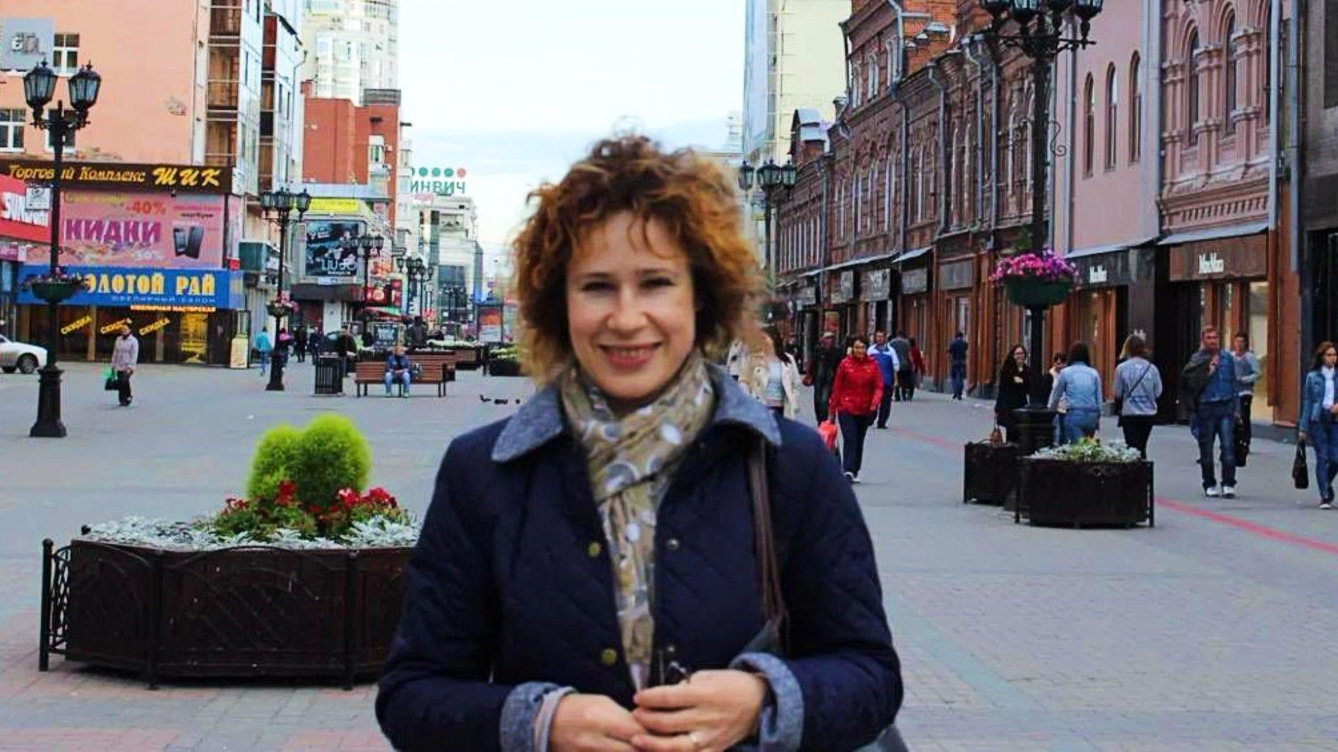 Julia Fenner smiling at the camera while standing in a shopping street