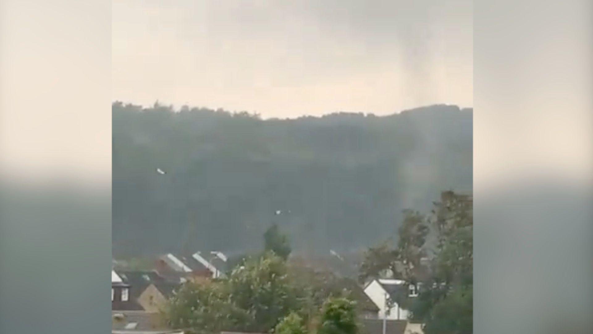 Footage shows debris caught up in strong, rotating winds during a storm.