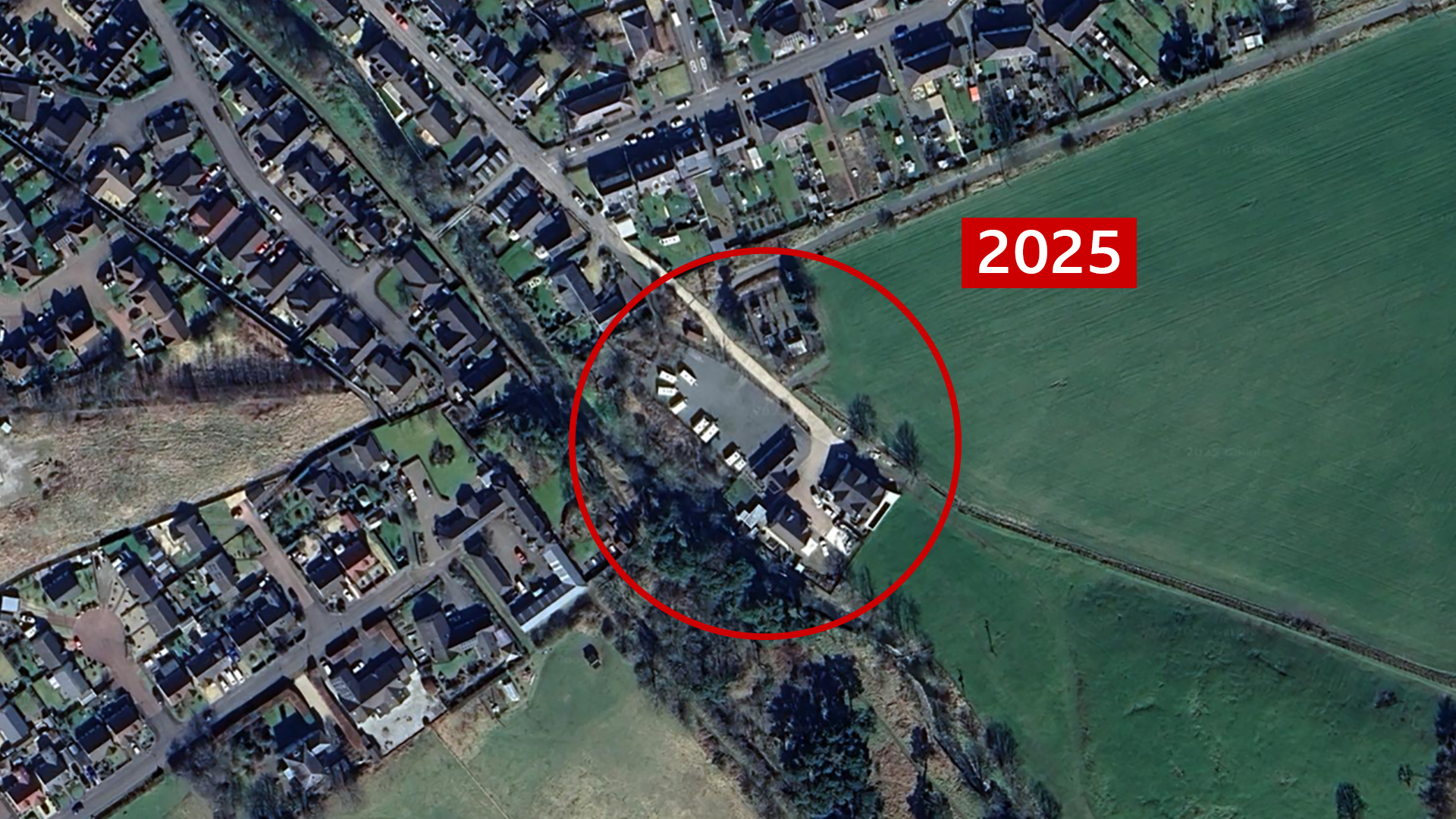 A satellite image of the site located in Innerleith near the Scottish Borders. The site is marked with a red circle in the centre and the year '2025' is also marked to the right, in red and white. It looks like a domestic area around the site and it is now a storage area. There is no greenery and it looks like it is a grey tarmac area with storage containers. 
