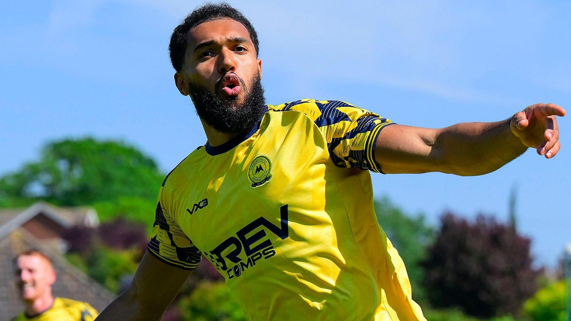 Deon Moore sticks his arms out wide as he celebrates scoring for Torquay United