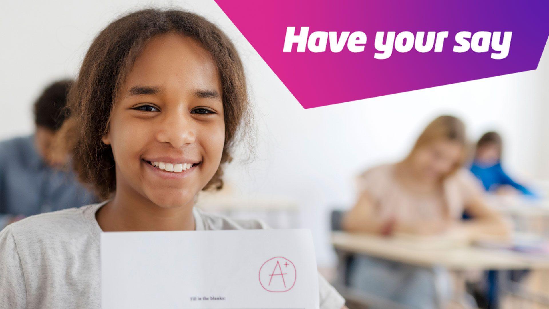 A child holding up an exam result paper with A+ on it, smiling. There is a text box in the top corner of the image saying "Have your say"