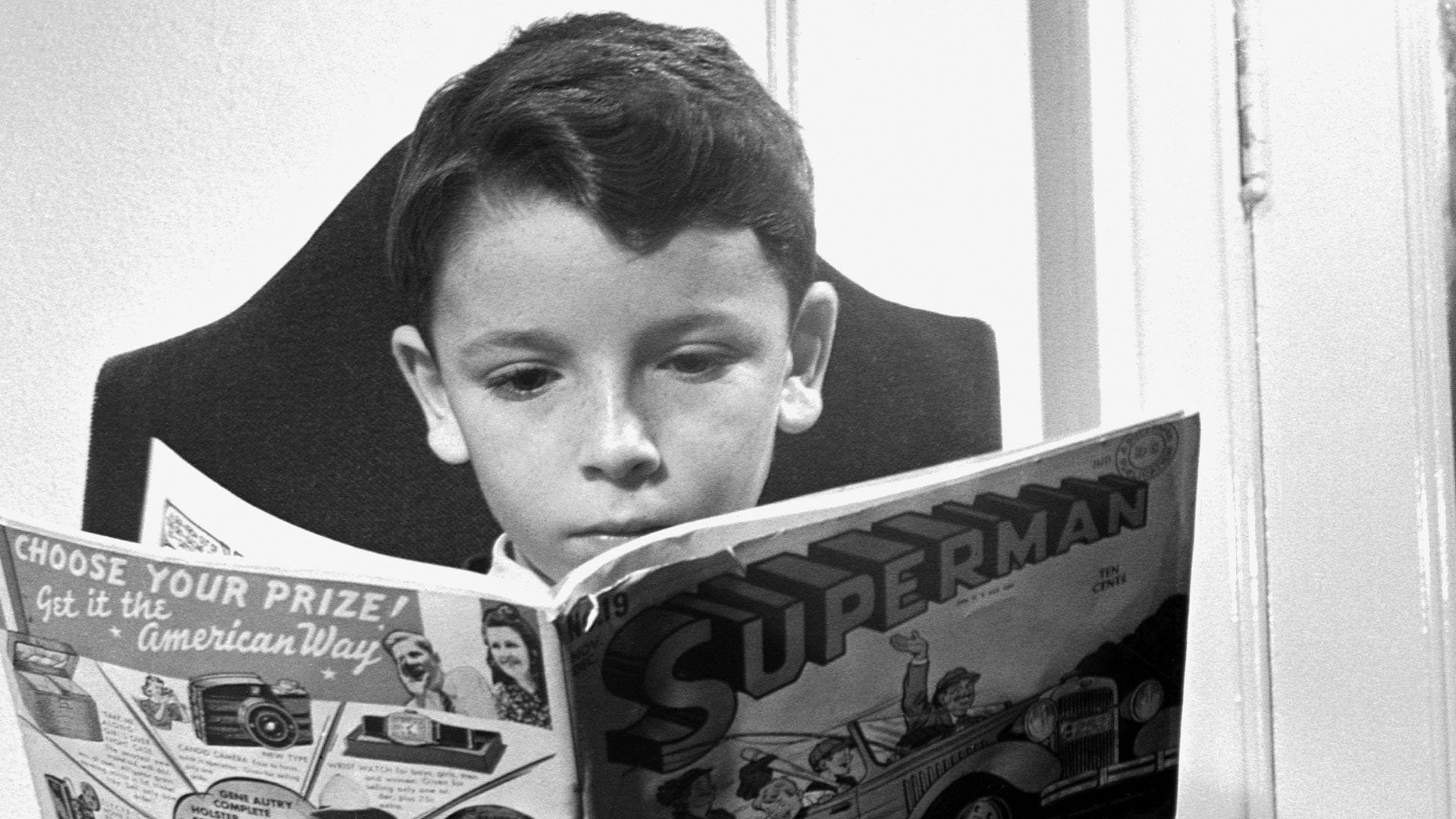 A black and white photo from 1942 of a child reading a Superman comic book