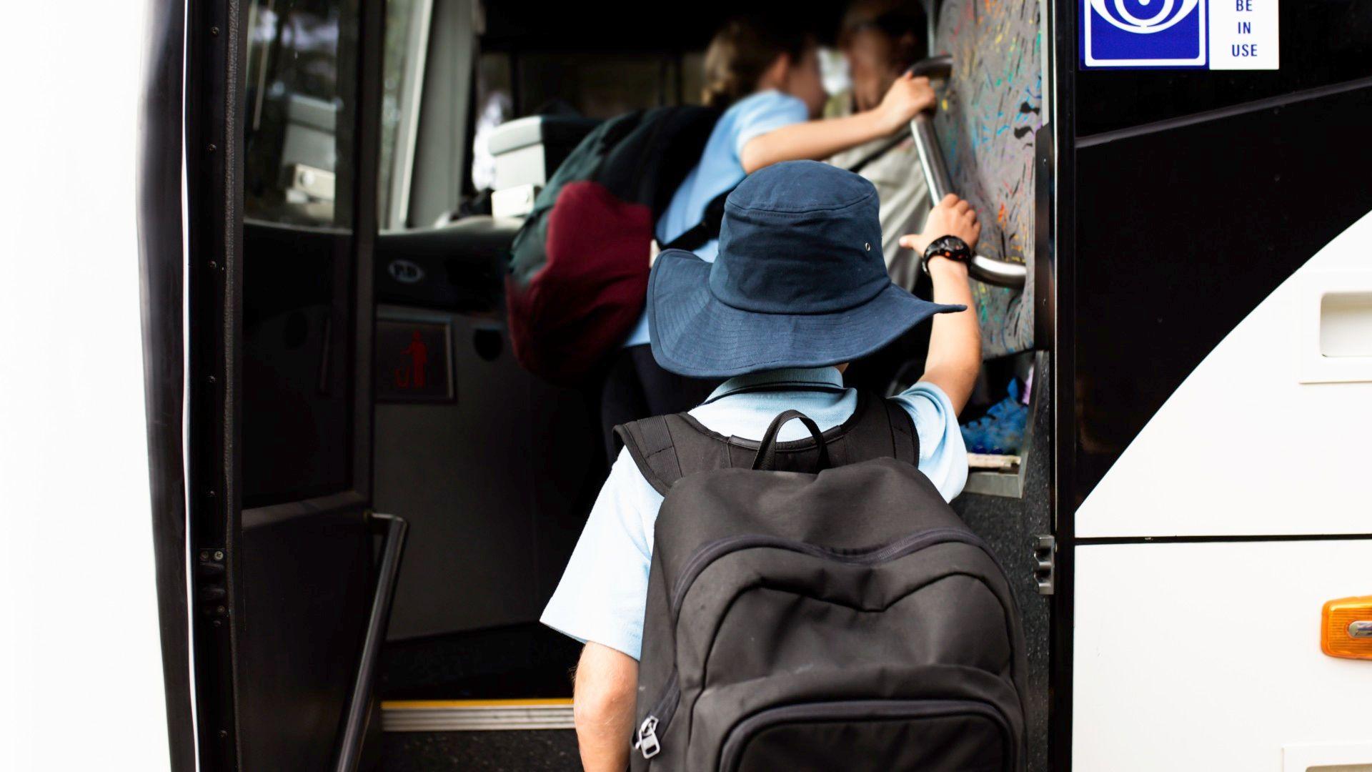 The entrance of a minibus with children boading.