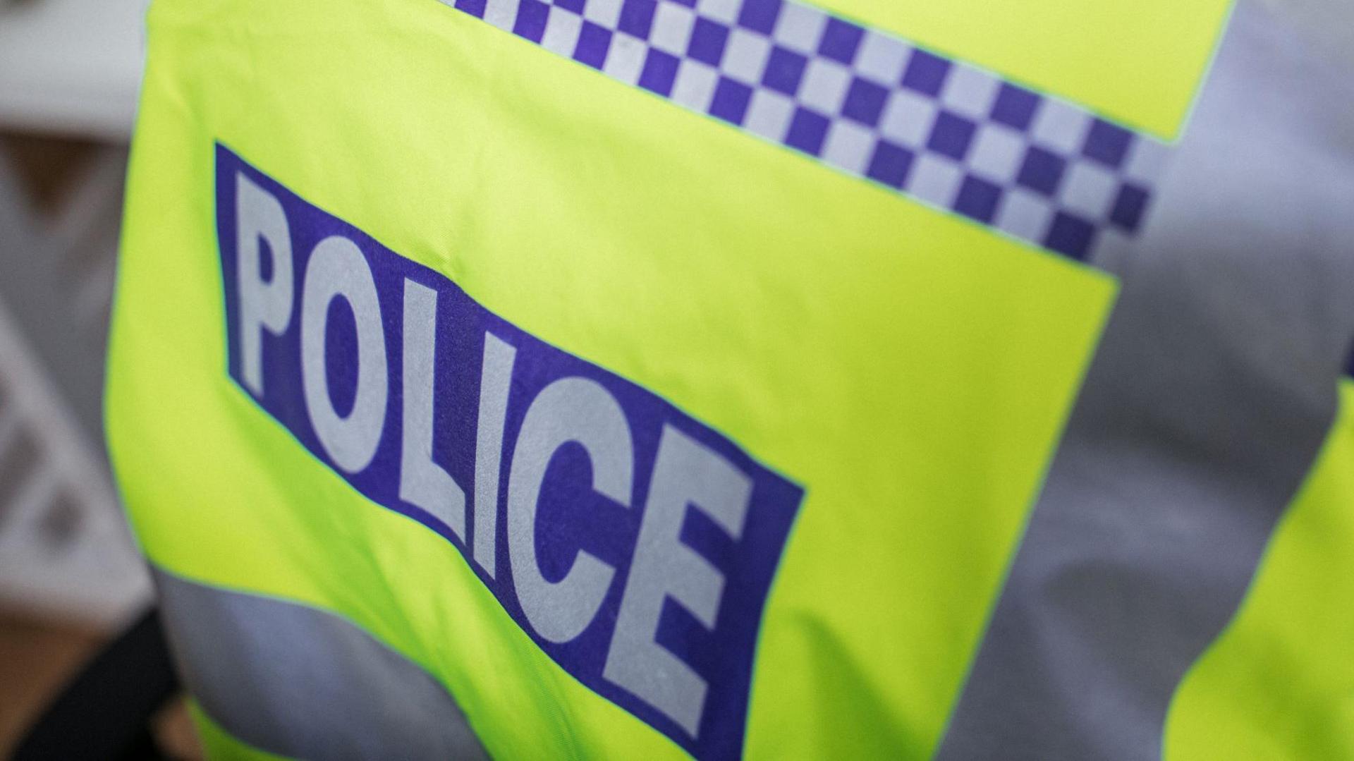 A stock image of the police badge on the back of a fluorescent jacket 