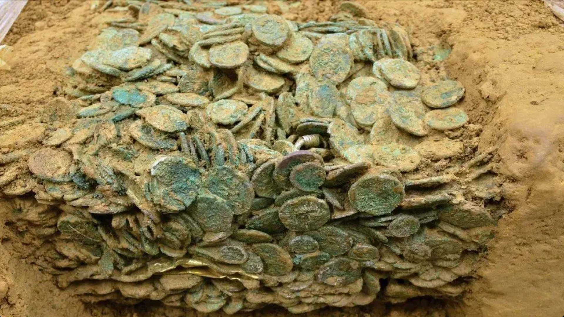 An image of the coin hoard half buried in the ground