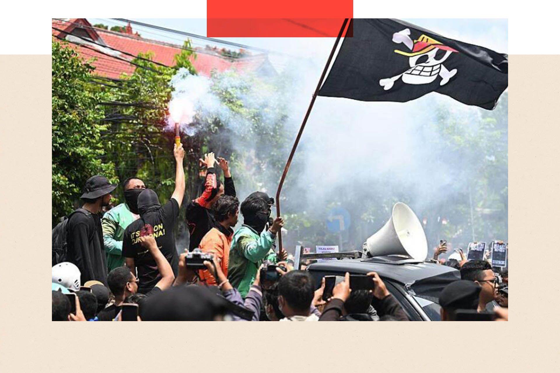 Protesters with raise a flag with the skull logo